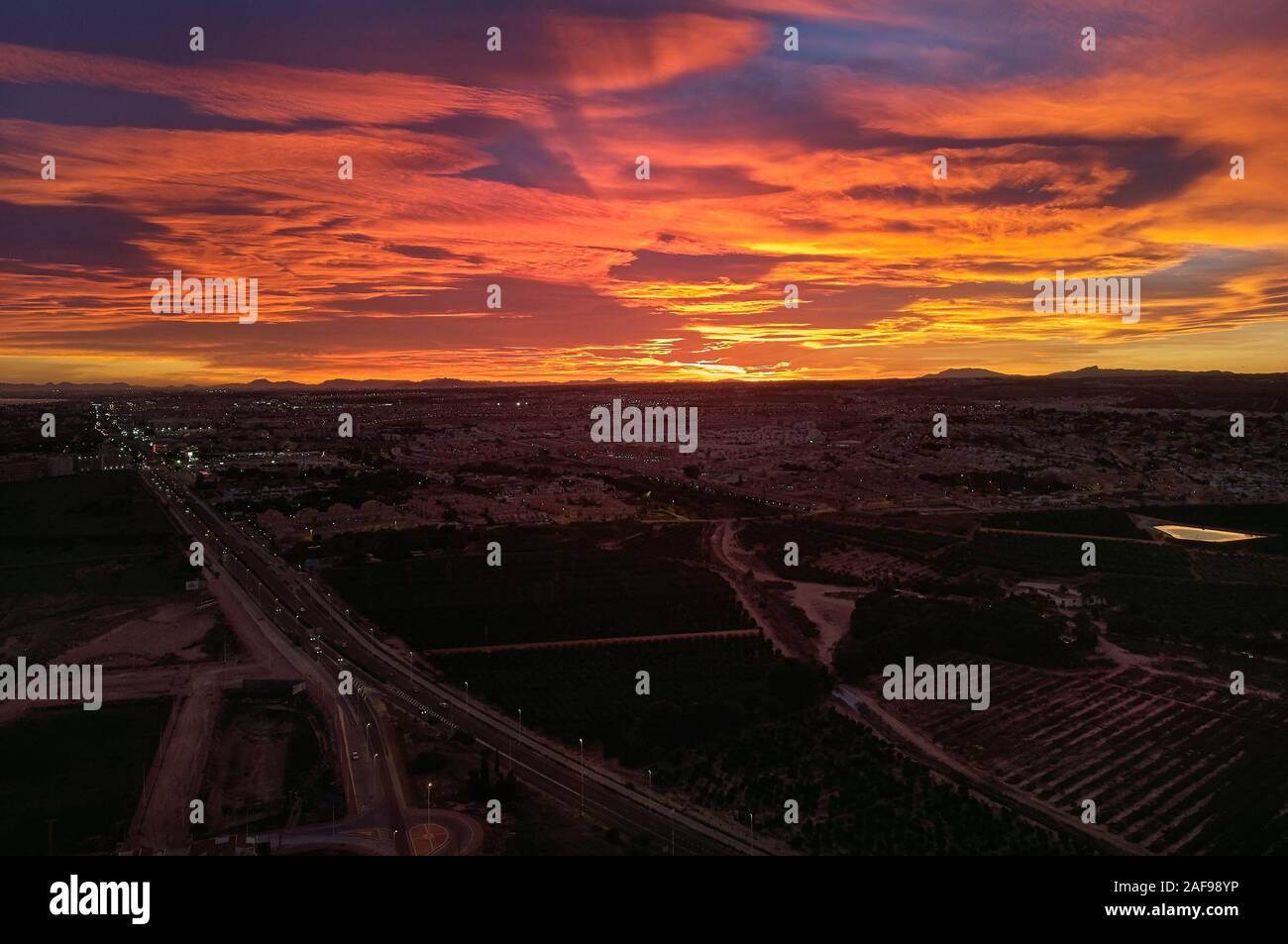 Photographie aérienne, Torrevieja paysage urbain espagnol pendant le coucher du soleil, orange ciel nuageux. Costa Blanca, Province d'Alicante, Espagne Banque D'Images
