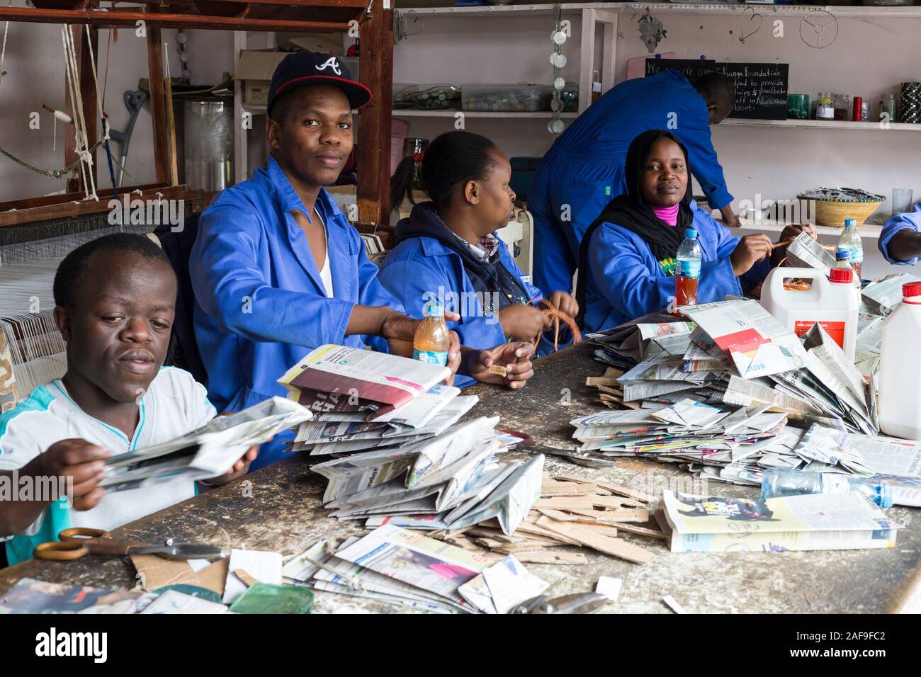 Arusha, Tanzanie. Des travailleurs sacs hors de journaux recyclés à Shangaï, Centre d'artisanat qui emploient des handicapés. Banque D'Images