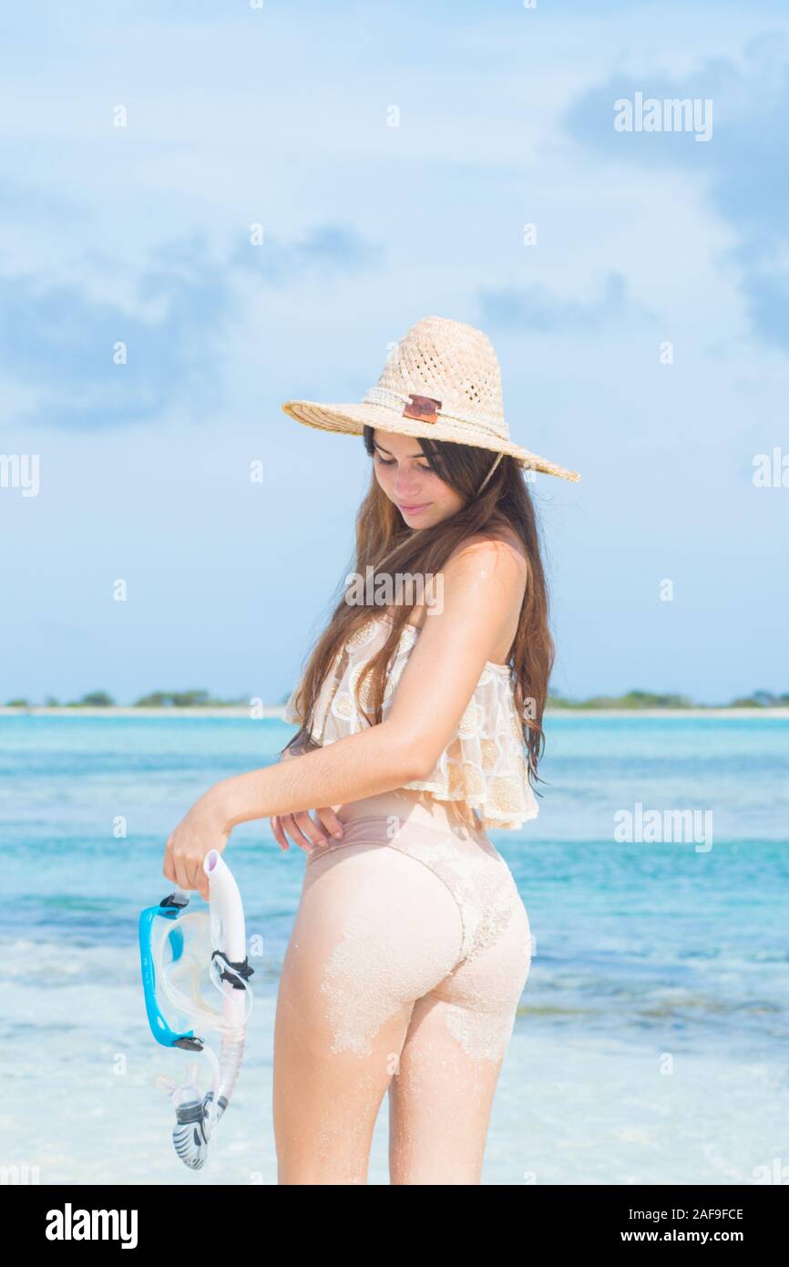 Jeune femme avec la peau humide et avec un tuba debout sur le sable et aller à nager dans la mer claire Banque D'Images