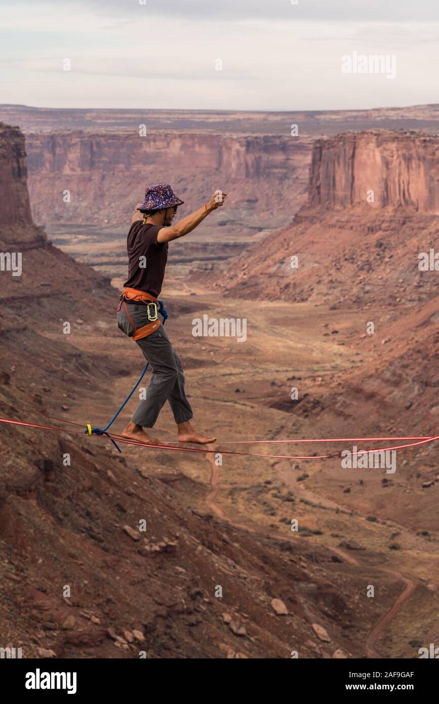 Un jeune homme slackline ou highlining des centaines de pieds au-dessus du Canyon de minéraux près de Moab, en Utah pendant un rassemblement highline. Banque D'Images