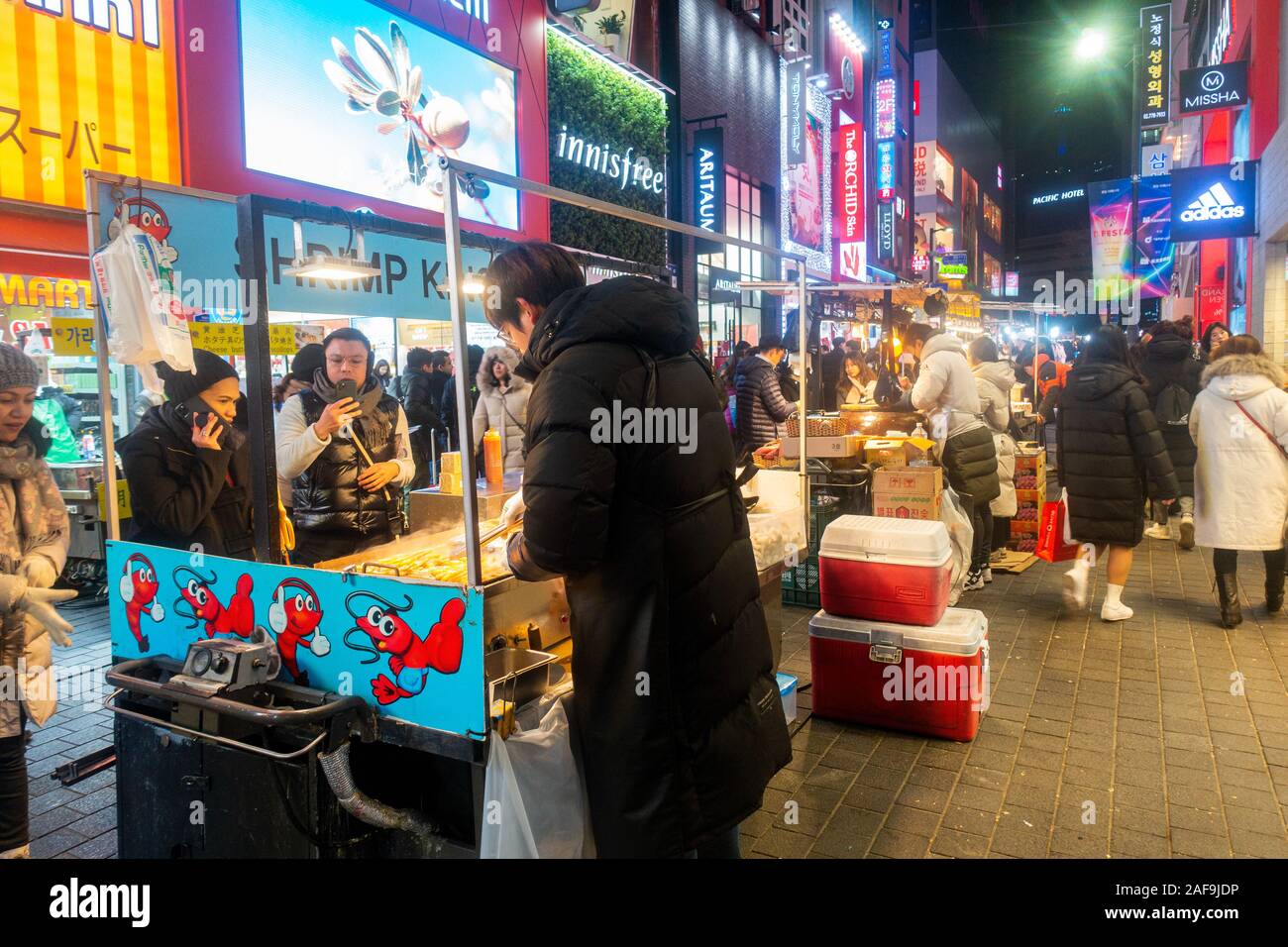 Séoul, Corée du Sud - Décembre 6th, 2019 : le district de Myeongdong à soir, site populaire pour les produits cosmétiques et de beauté et de l'alimentation de rue. Banque D'Images