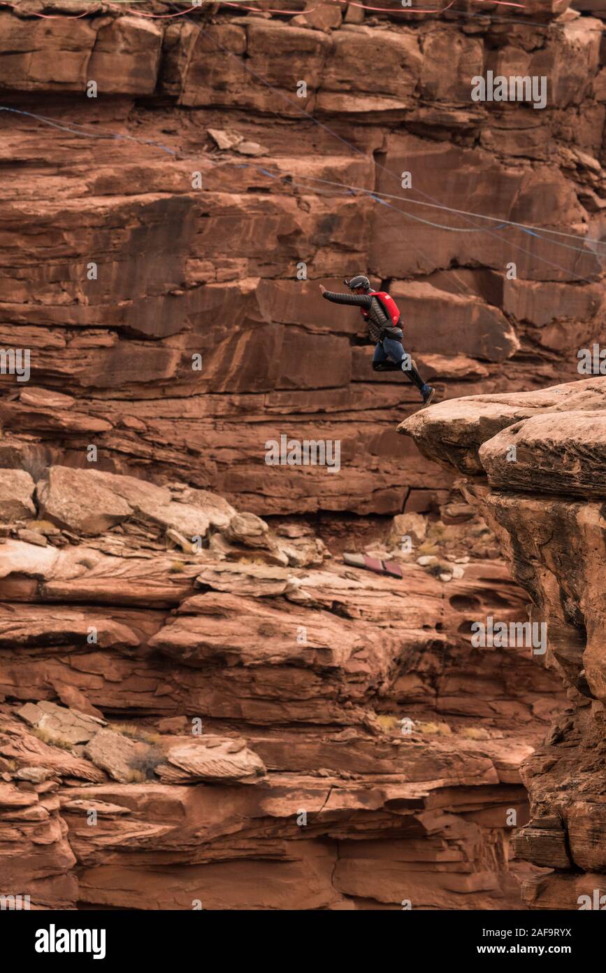 Un cavalier BASE saute clifftop 950 pieds au-dessus du plancher de minéral Canyon près de Moab, Utah. Banque D'Images