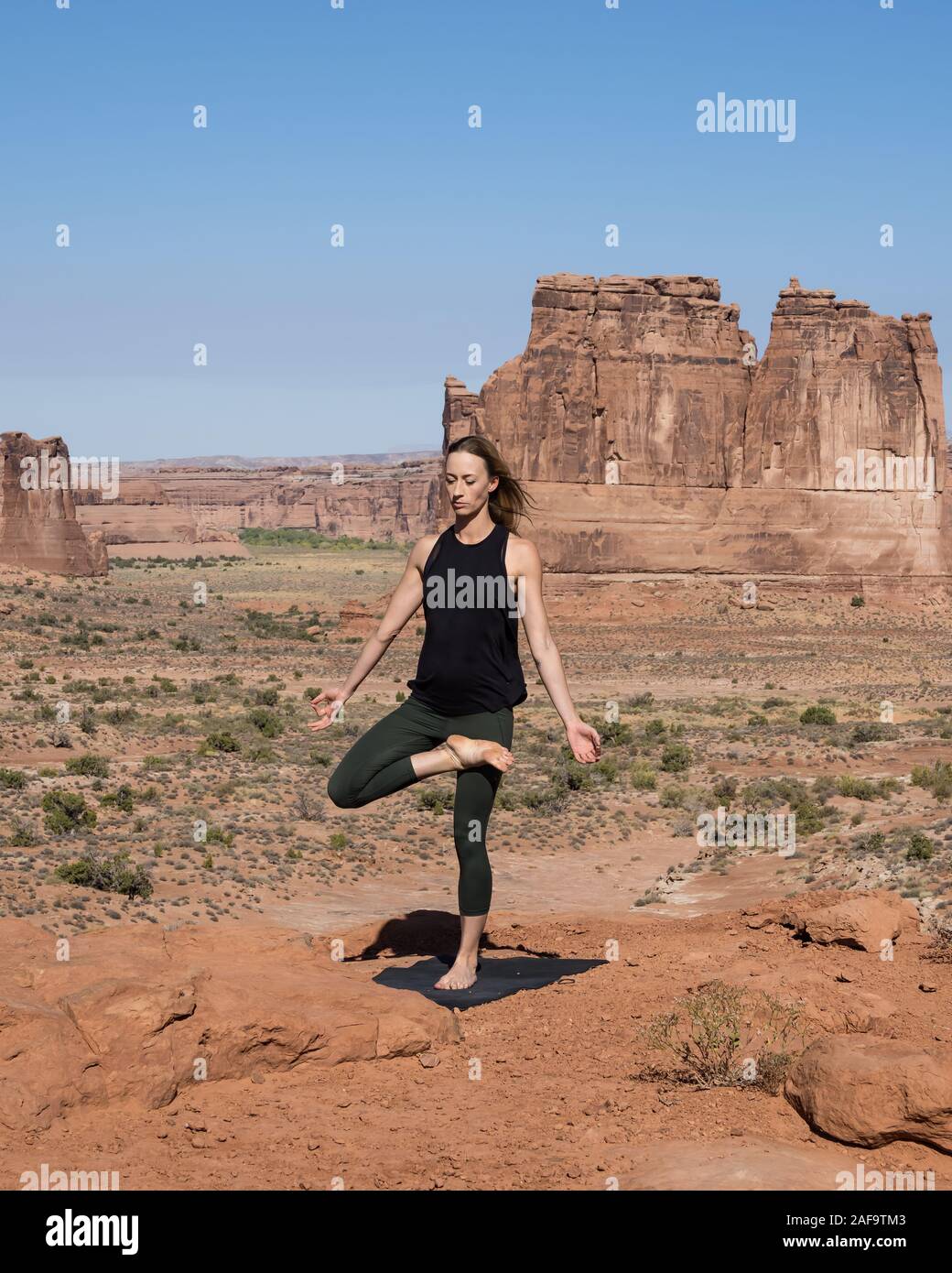 Une jolie jeune femme pratique le yoga à Montagnes La Sal oublier dans Arches National Park près de Moab, Utah. Banque D'Images