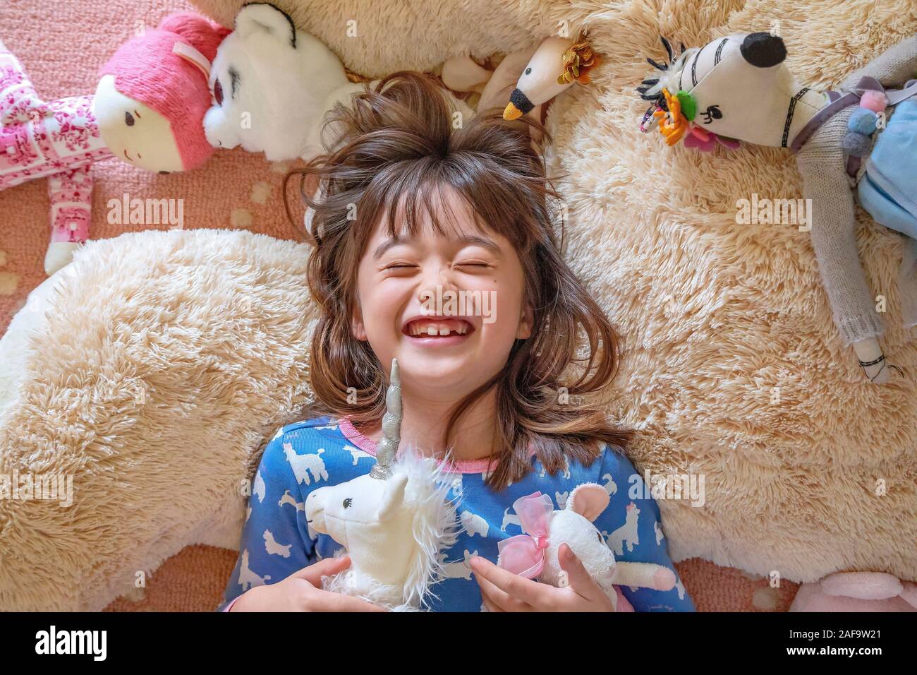 Sept ans, fille, jouant avec ses jouets Banque D'Images