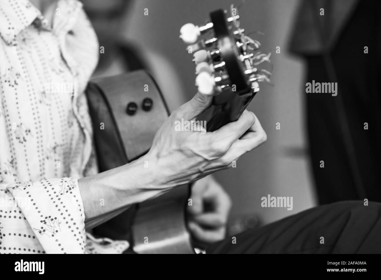 Arrière-plan de la musique live. Mains fortes d'un guitariste acoustique. Retro photo noir et blanc stylisé avec soft focus sélectif Banque D'Images
