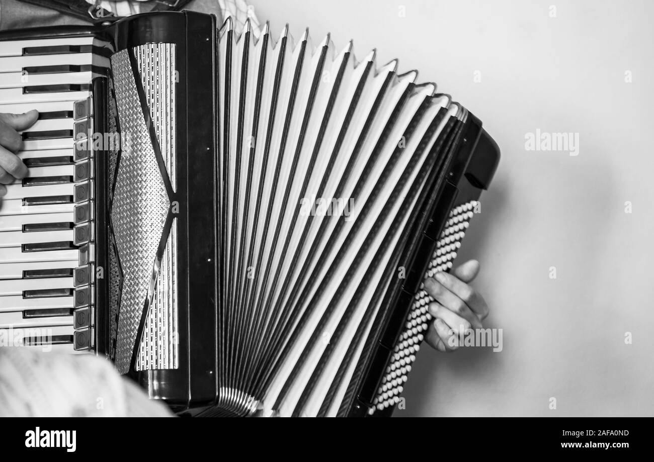 L'accordéoniste joue vintage accordéon. Retro photo noir et blanc stylisé Banque D'Images