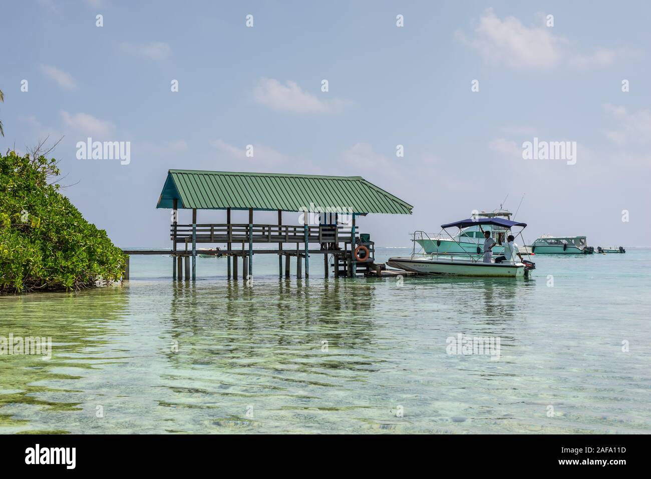 Kuda Huraa, Maldives - 19 novembre 2017 : Une jetée sur la rive avec des palmiers sur l'île de Kuda Huraa, Maldives, océan Indien. Banque D'Images