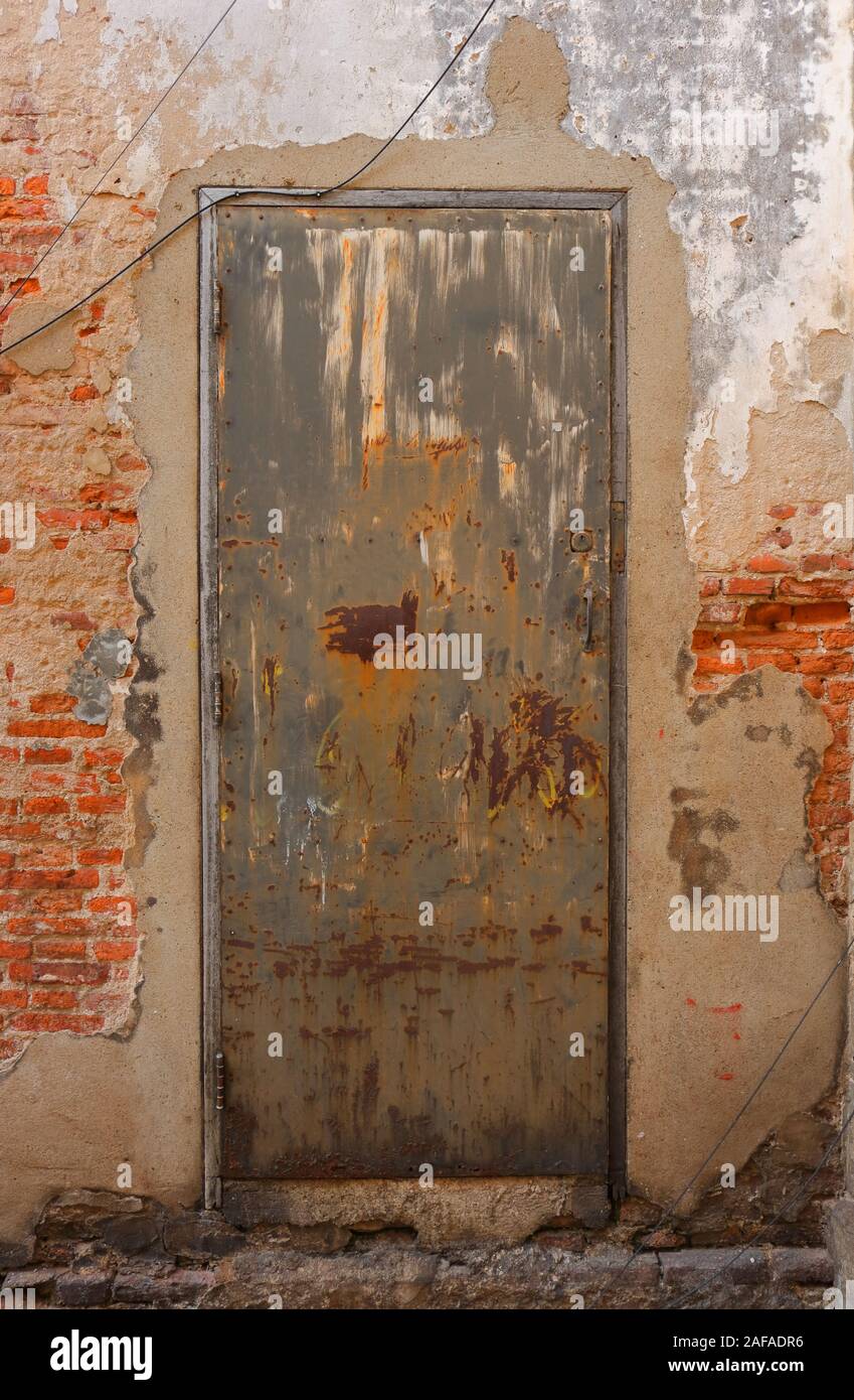Libre négligé vintage porte en acier rouillé avec porte en bois sur mur de brique avec ciment plâtre Banque D'Images
