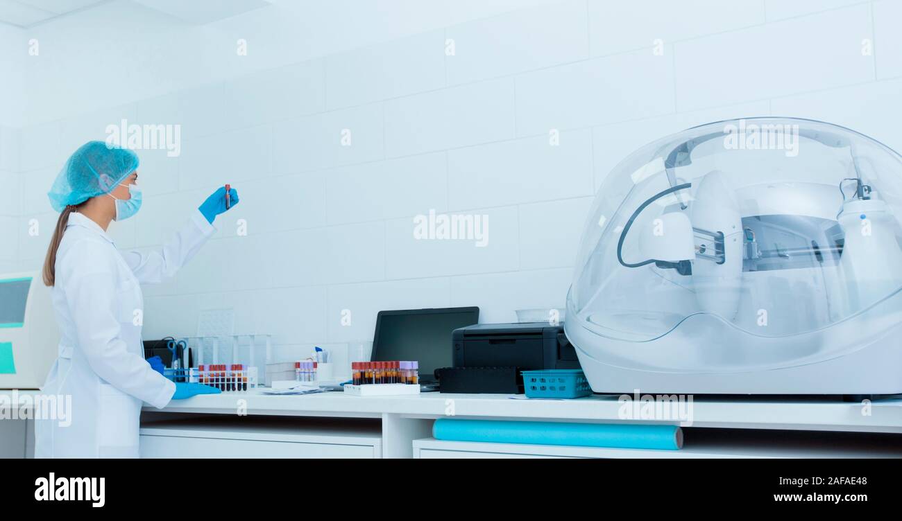 Young female medical worker holding tube avec l'échantillon de sang Banque D'Images