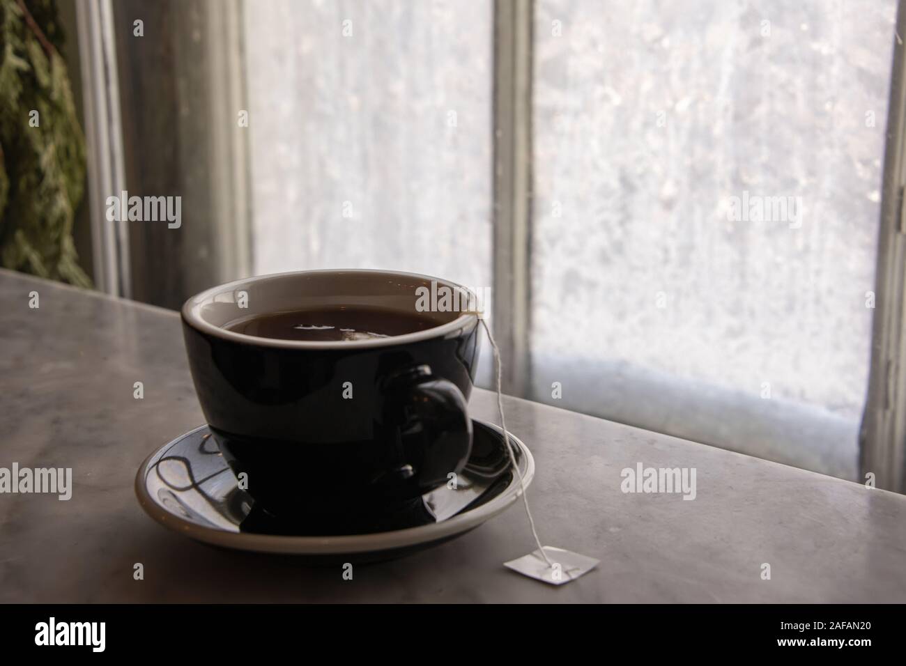 USA, Boston - Janvier 2018 - tasse de thé chaud sur un rebord de fenêtre en marbre devant un verre recouvert de glace de la fenêtre Banque D'Images