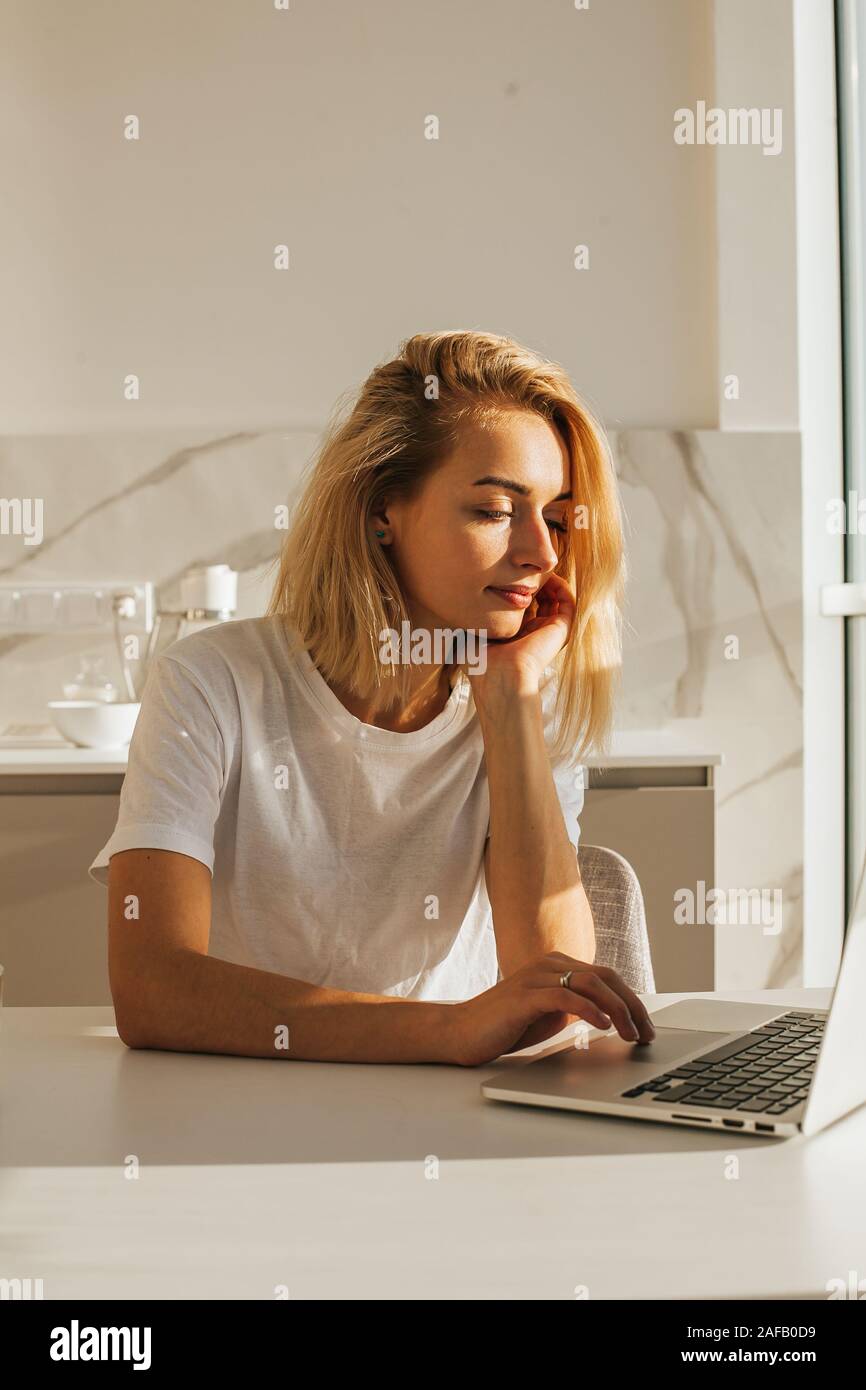 Belle jeune femme utilisant un ordinateur portable à la maison Banque D'Images