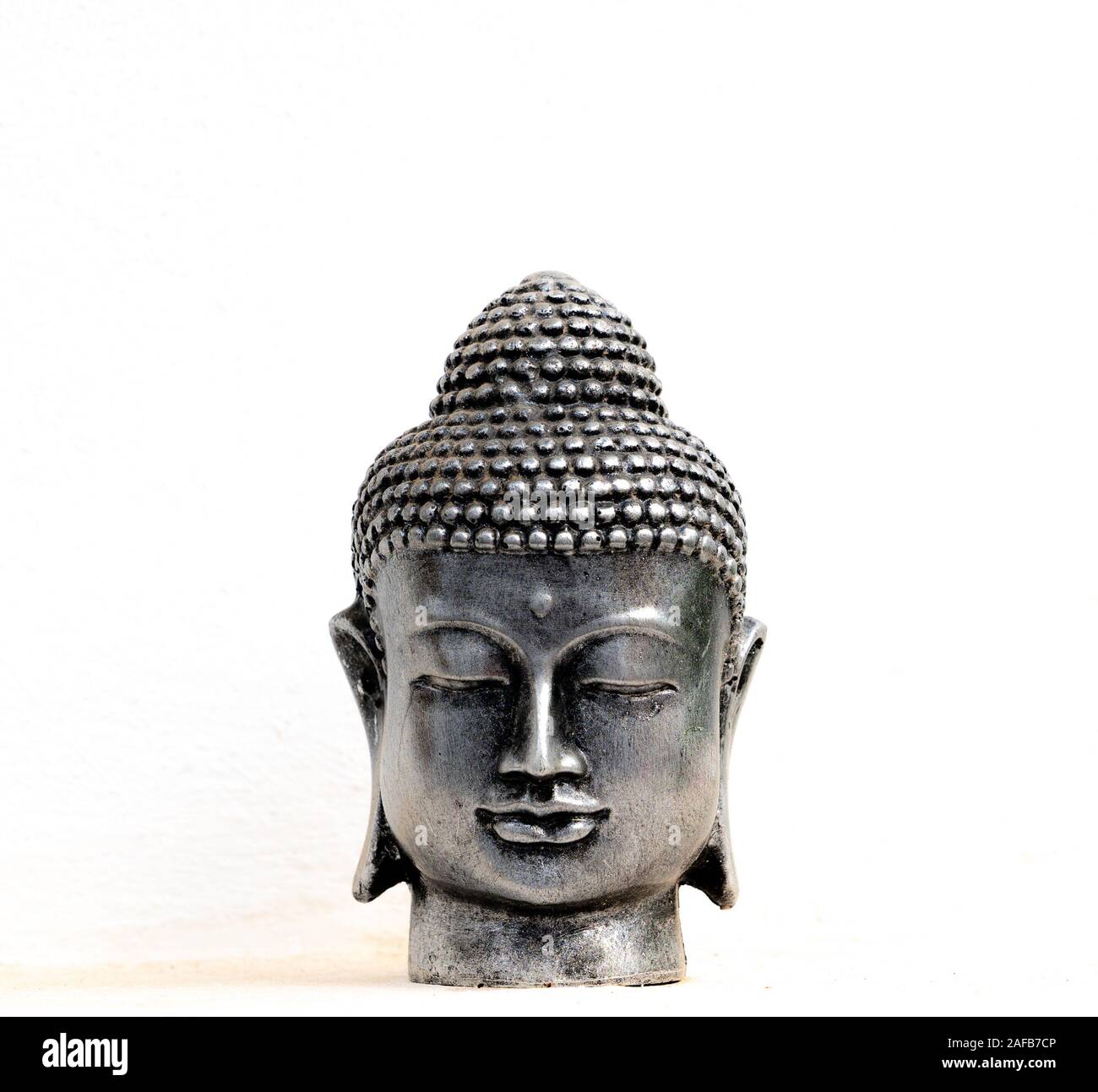 Tête de Bouddha en argent avec fond blanc Banque D'Images