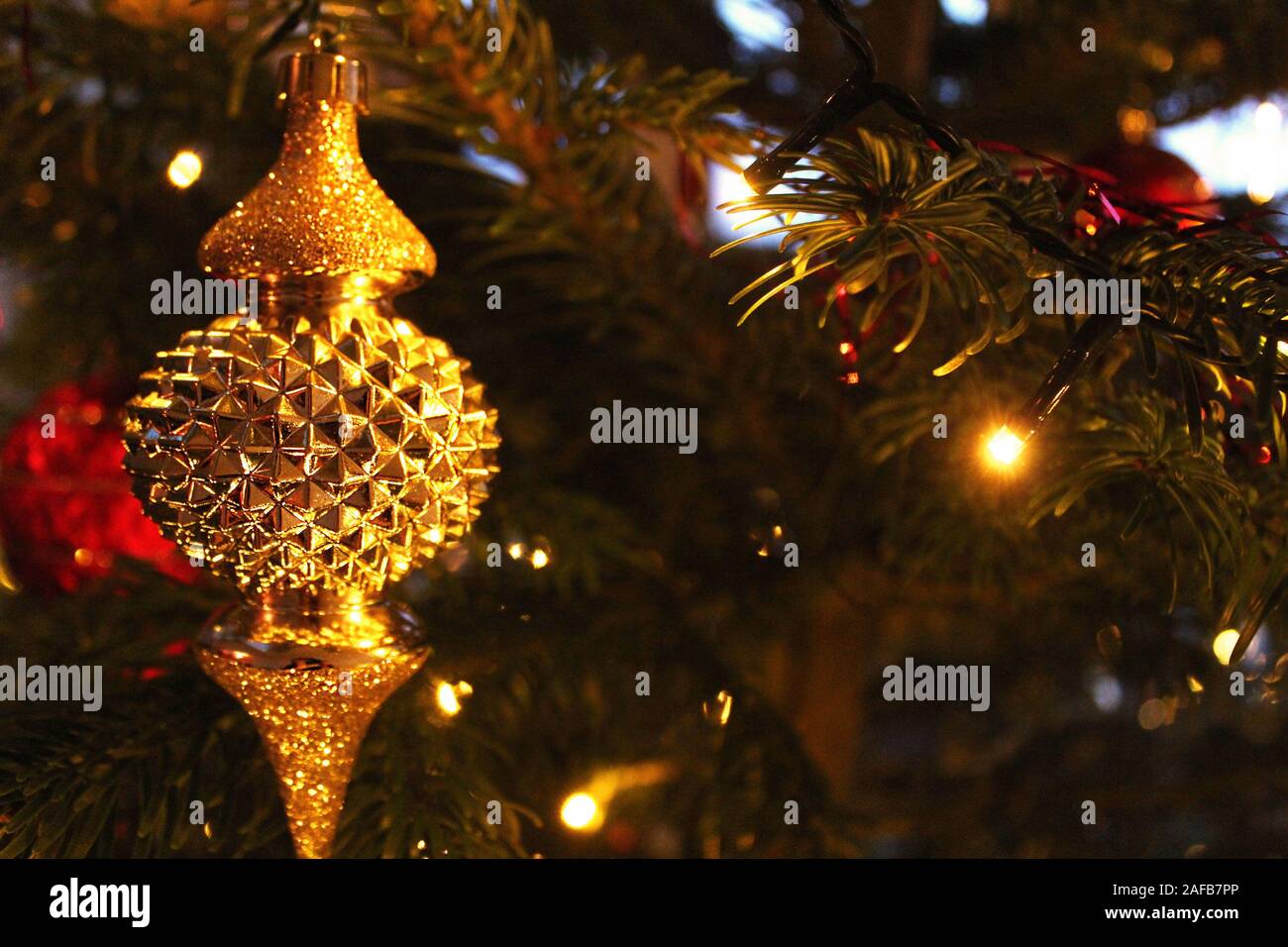 Ornement de Noël d'or sur un arbre de Noël décoré Banque D'Images