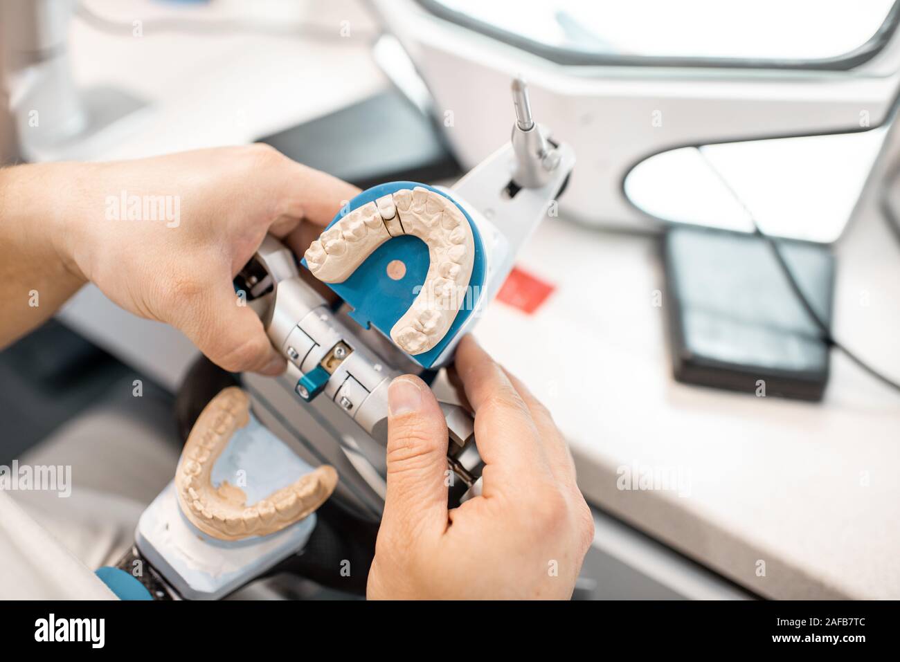 Technicien dentaire articulateur et travailler avec le modèle de la mâchoire au laboratoire, close-up view Banque D'Images