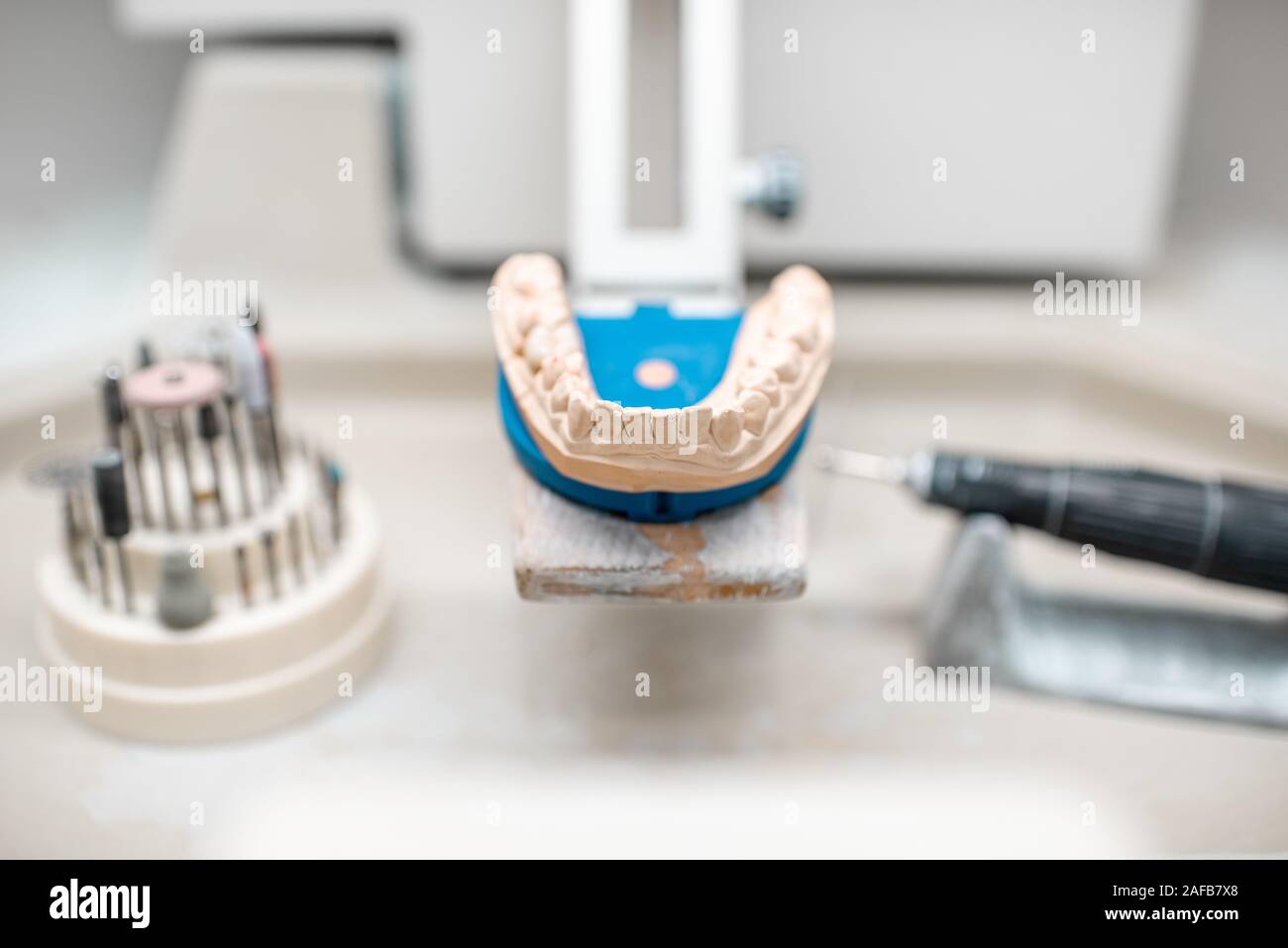 Mâchoire artificielle pour la modélisation des implants avec jeu de fraises dentaires sur le lieu de travail de technicien en laboratoire dentaire Banque D'Images