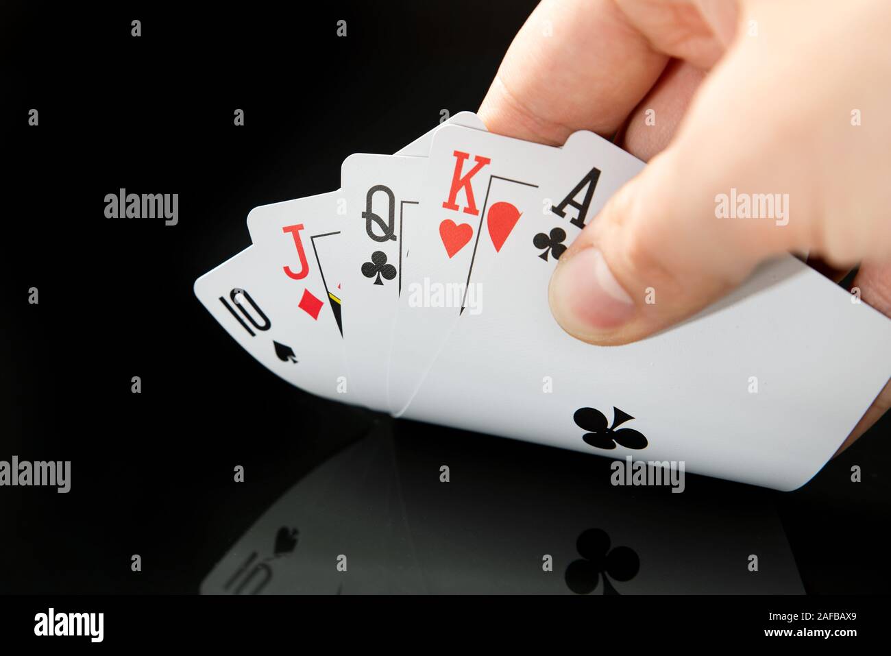 Man holding cartes sur table noire avec réflexion. Jouer au poker, le jeu de casino en concept. Banque D'Images