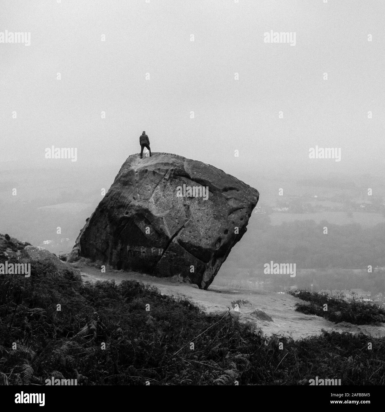 Une personne se trouve sur le dessus du mollet (de la vache et du veau Rocks sur Ilkley Moor) et admire la vue, Ilkley, West Yorkshire, Royaume-Uni Banque D'Images