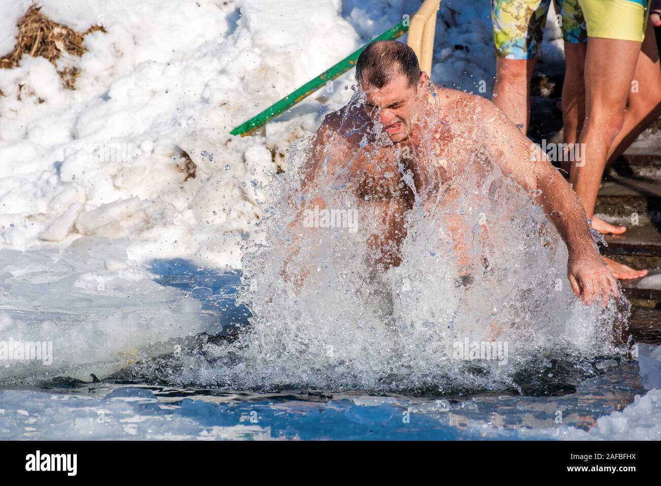 Uzhhorod, Ukraine - 19 JAN 2017 l'épiphanie : le bain sur une journée ensoleillée. Dieu a béni la tradition des vrais chrétiens orthodoxes. trempant dans les eaux glacées de l'Alps avec trous Banque D'Images