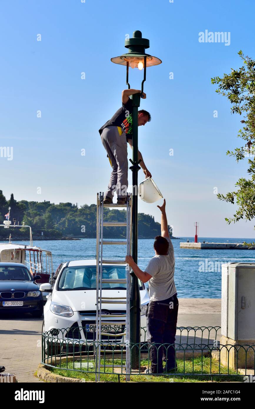 Façon intéressante pour changer une ampoule sur une rue de ville lamp post Banque D'Images