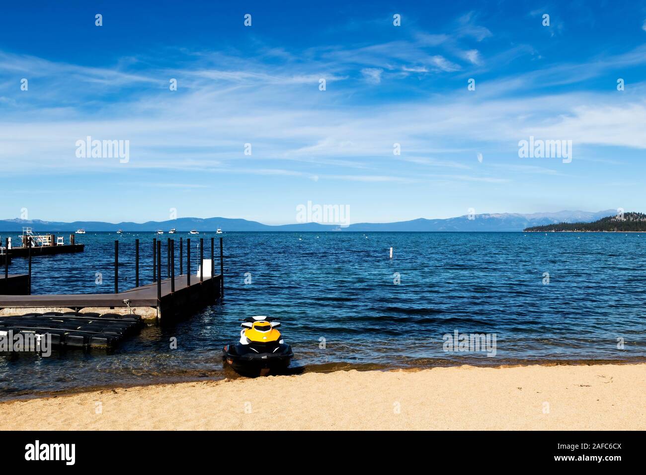 South Lake Tahoe avec Ciel Bleu nuages blancs de quais et de Jet Ski sur la plage de sable Banque D'Images