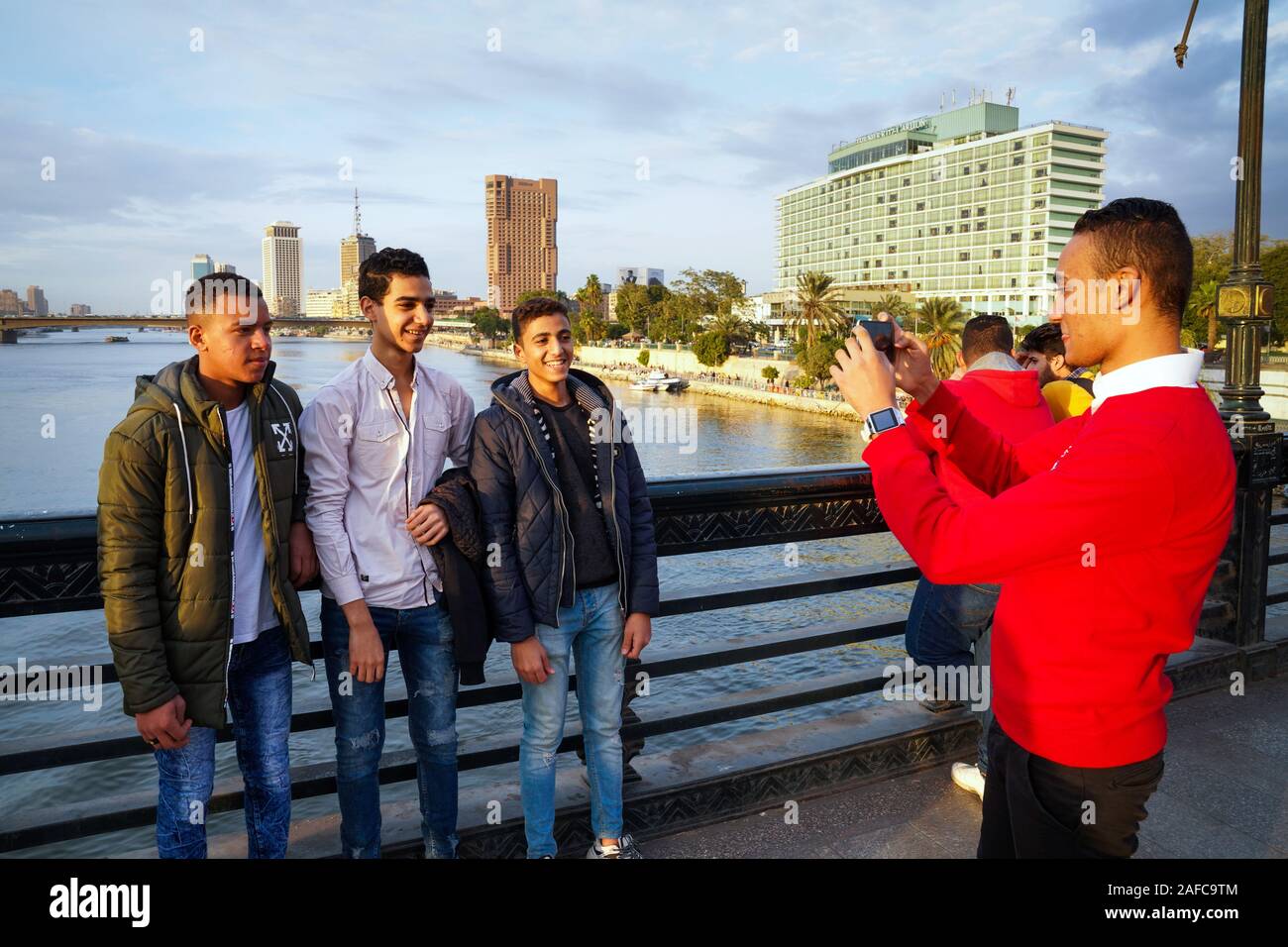 Les jeunes hommes de prendre des photos d'eux-mêmes sur un pont sur le Nil au Caire, Egypte Banque D'Images