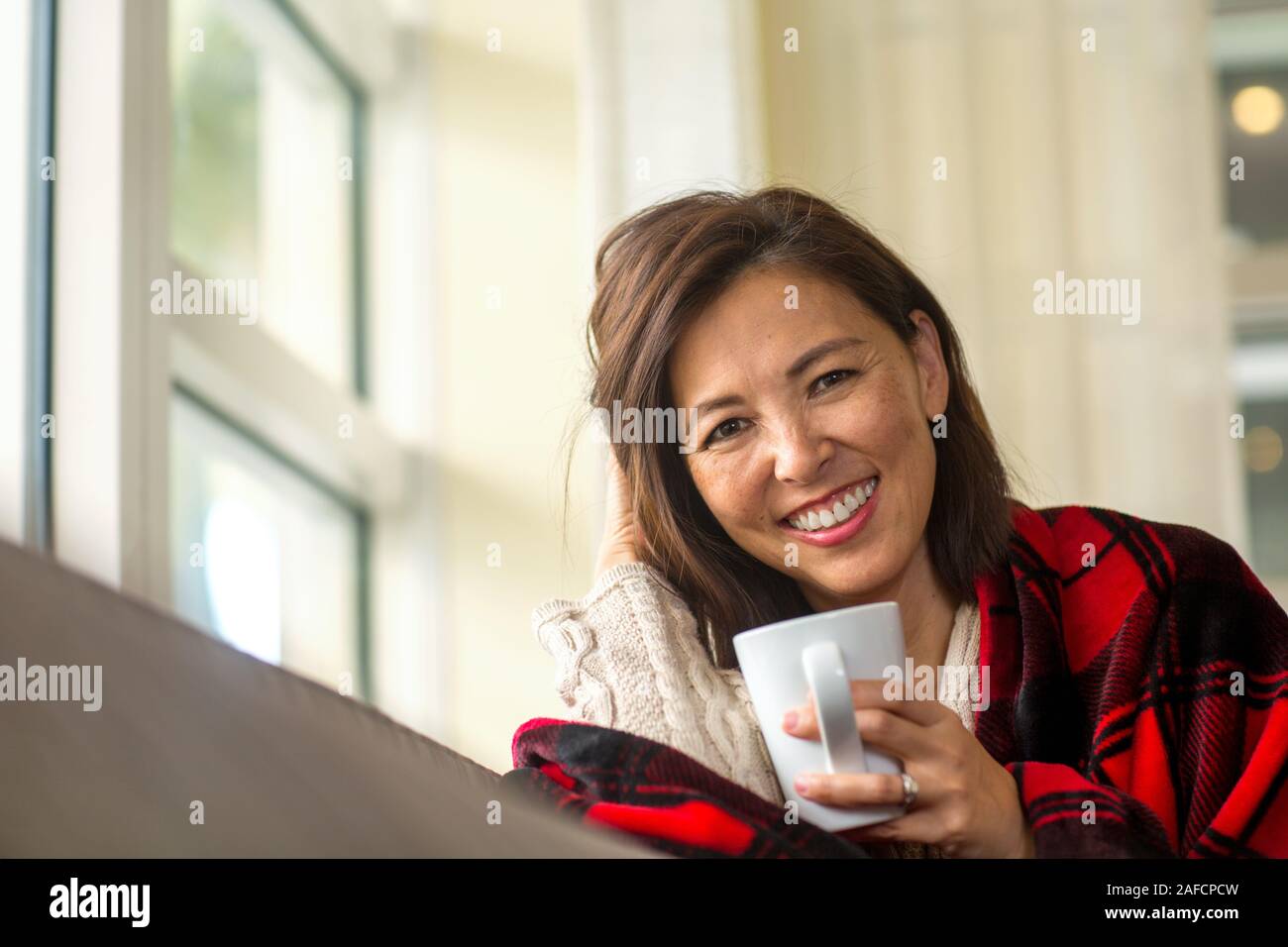 Femme asiatique mûre appréciant une tasse de café. Banque D'Images