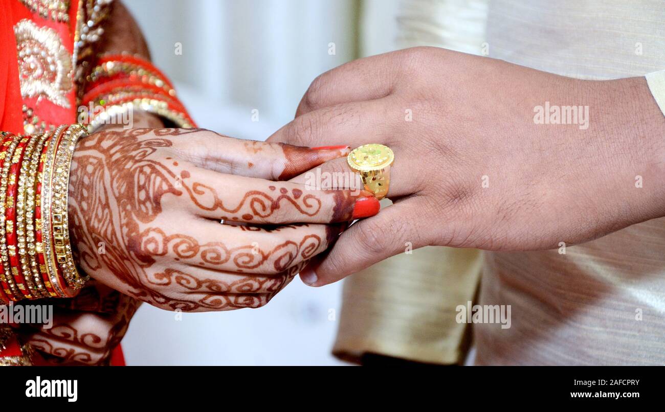 Mariée indienne mettant un anneau de mariage sur le doigt du marié Banque D'Images