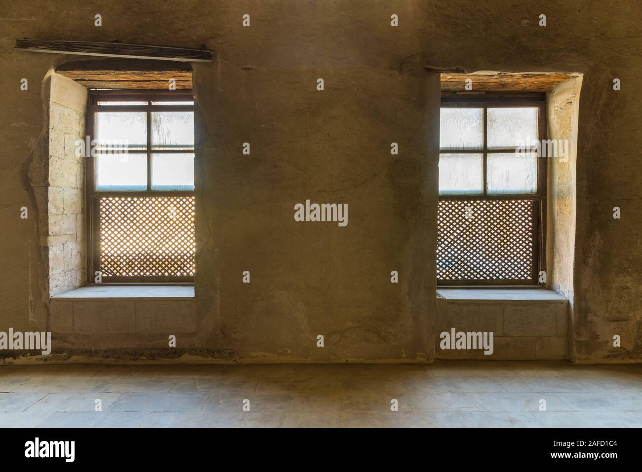 Deux fenêtres ornées de bois grunge Entrelacé - Mashrabiya - dans mur de pierre à l'édifice abandonné, Le Caire, Égypte médiévale Banque D'Images