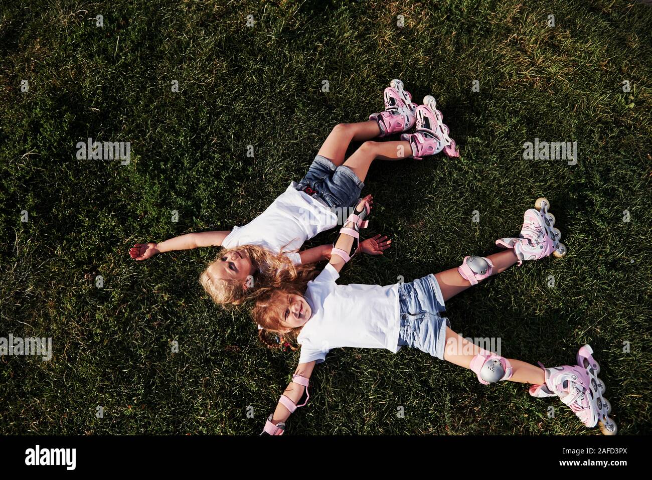 Vue d'en haut. Sentiment de liberté. Deux enfants allongés sur l'herbe verte à l'été Banque D'Images