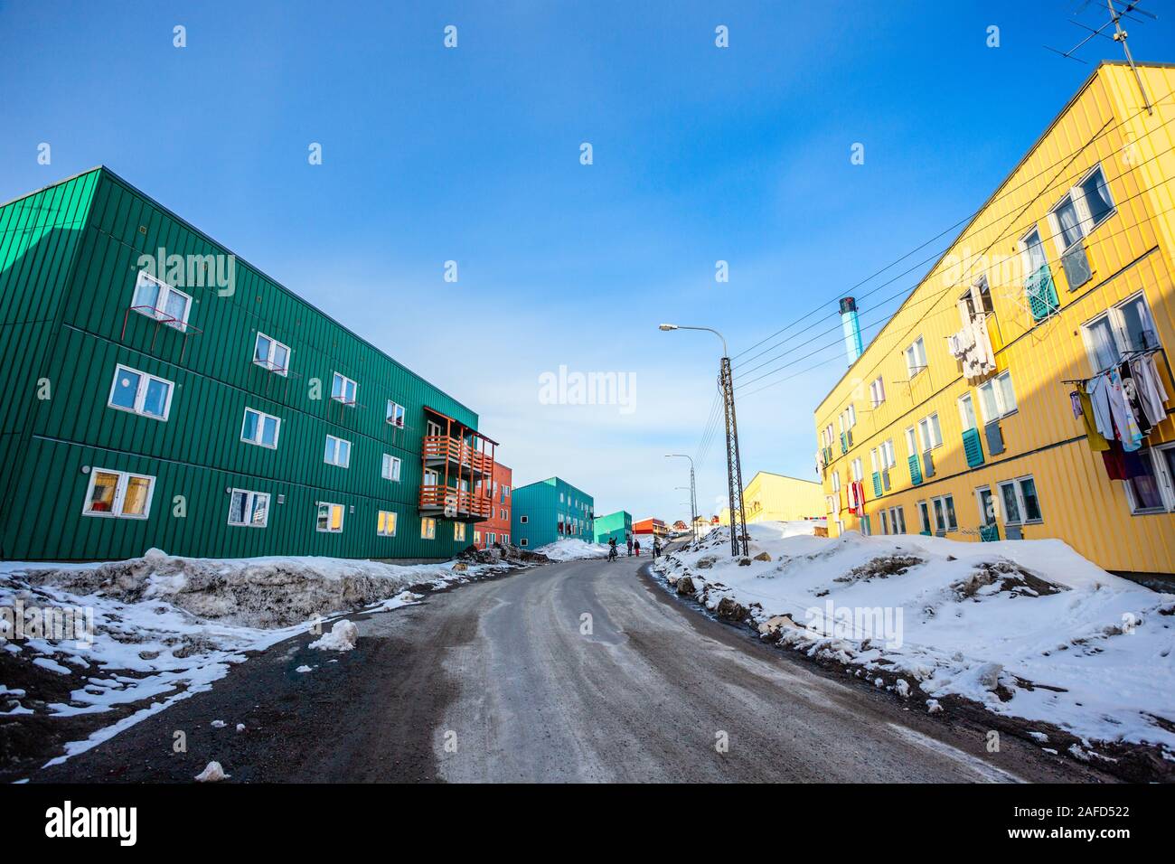 Route boueuse avec de la neige et des blocs de vie avec de longs bâtiments de faible hauteur dans la ville d'Ilulissat, Groenland Banque D'Images Route boueuse avec de la neige et des blocs de vie avec de longs bâtiments de faible hauteur dans la ville d'Ilulissat, Groenland Banque D'Images