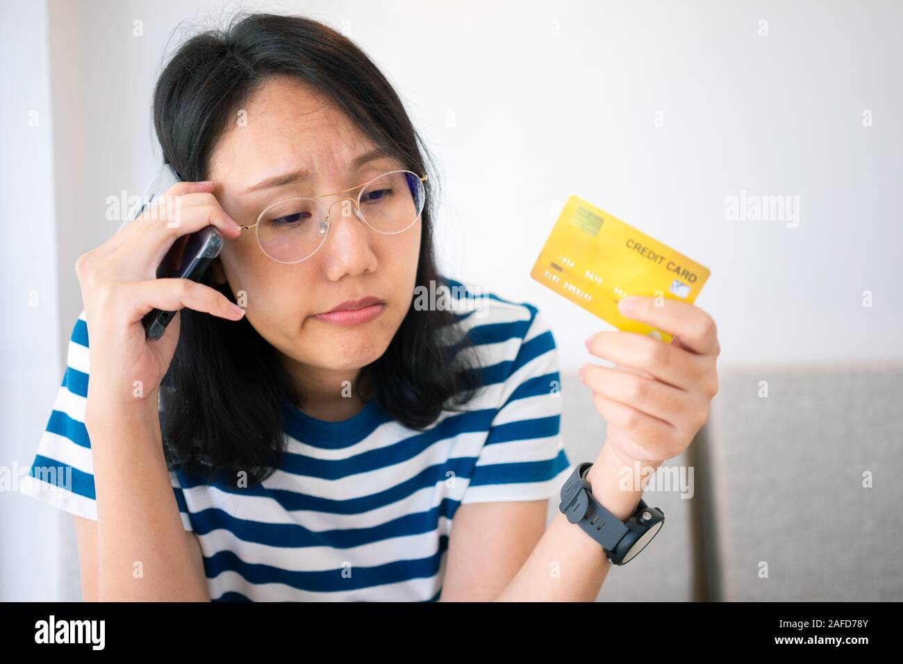 Portrait confus young woman holding credit cards avoir problème en ligne Paiement par carte de crédit faire rejeté unsecure. carte de crédit Paiement en ligne Banque D'Images