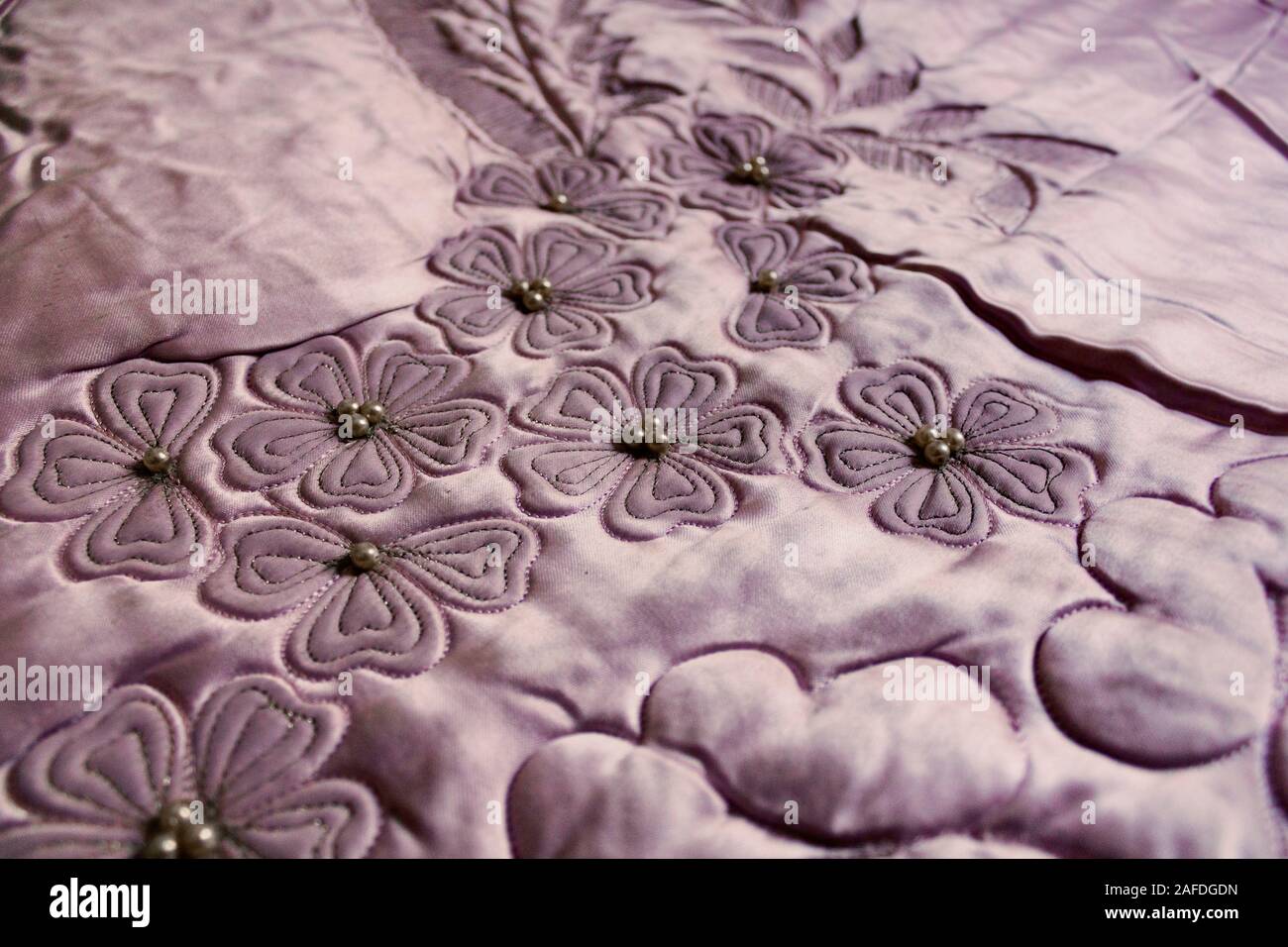 Quilting à la main est toujours très populaire. Close up image d'une courtepointe avec feuilles et pétales de perles, à partir de 1950. Banque D'Images