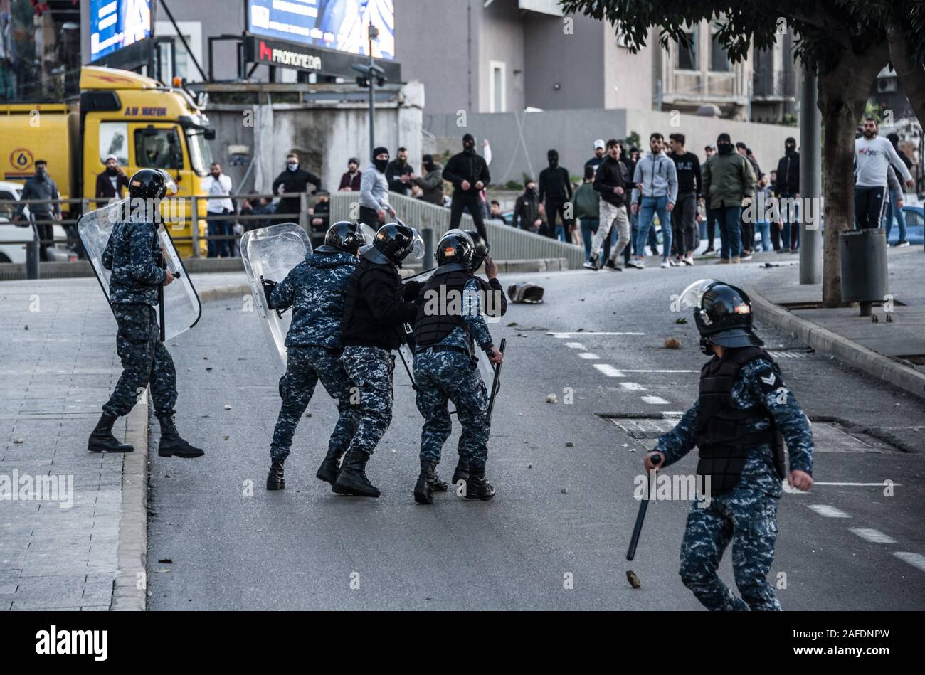 Beyrouth, Liban. 14 Décembre, 2019. Le personnel des forces de sécurité face à face avec des gens qui protestent contre une révolte contre le gouvernement libanais sur la 59e journée de protestation. Du quartier chiite de Bachoura, près du centre-ville de Beyrouth, des contre-manifestants ont attaqué la police et le personnel de l'armée avec des pierres et des feux d'artifice le samedi soir. La police a répondu par des gaz lacrymogènes lors d'une bataille de plusieurs heures. Credit : Elizabeth Fitt/Alamy Live News Banque D'Images