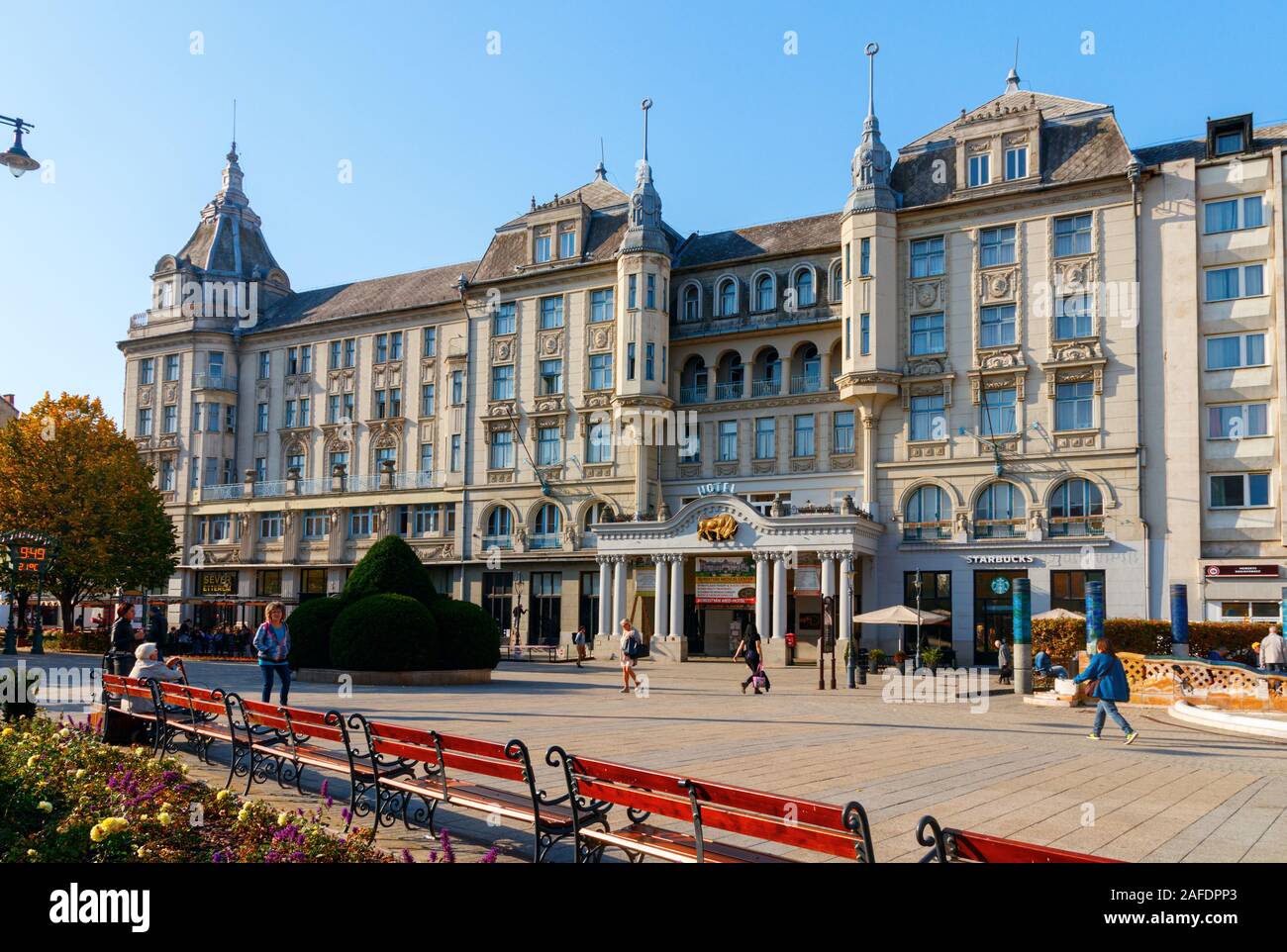 Kossuth Square avec la façade néoclassique de l'Grand Hotel Aranybika sous un ciel bleu. Debrecen, Hongrie. Banque D'Images