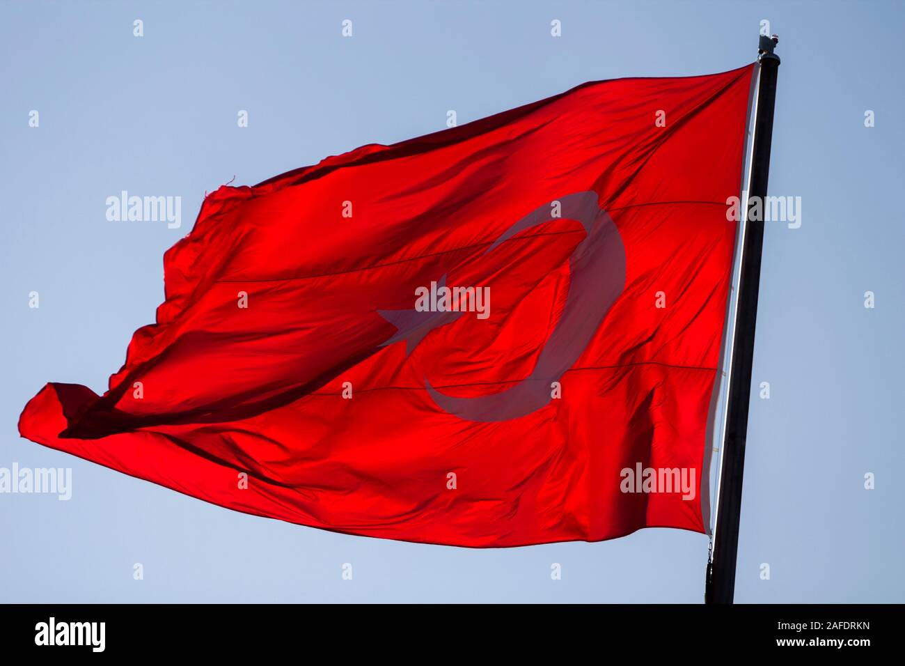 Près d'un drapeau turc, rouge, sous le soleil du soir. Banque D'Images