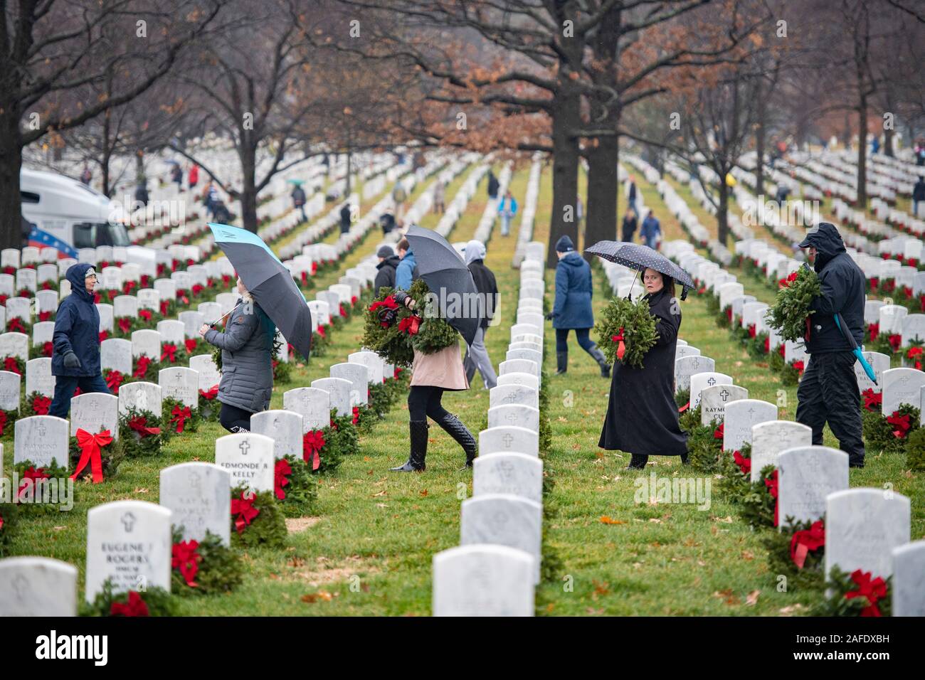 Arlington, États-Unis d'Amérique. 14 Décembre, 2019. Les bénévoles portent des couronnes pour placer sur les tombes de membres de l'ensemble des couronnes au cours de la 28e Journée de l'Amérique au cimetière national d'Arlington, le 14 décembre 2019 à Arlington, en Virginie. Plus de 38 000 couronnes au lieu des bénévoles chaque tombe au cimetière national d'Arlington et autres sites autour de la nation. Credit : Elizabeth Fraser/DOD/Alamy Live News Banque D'Images