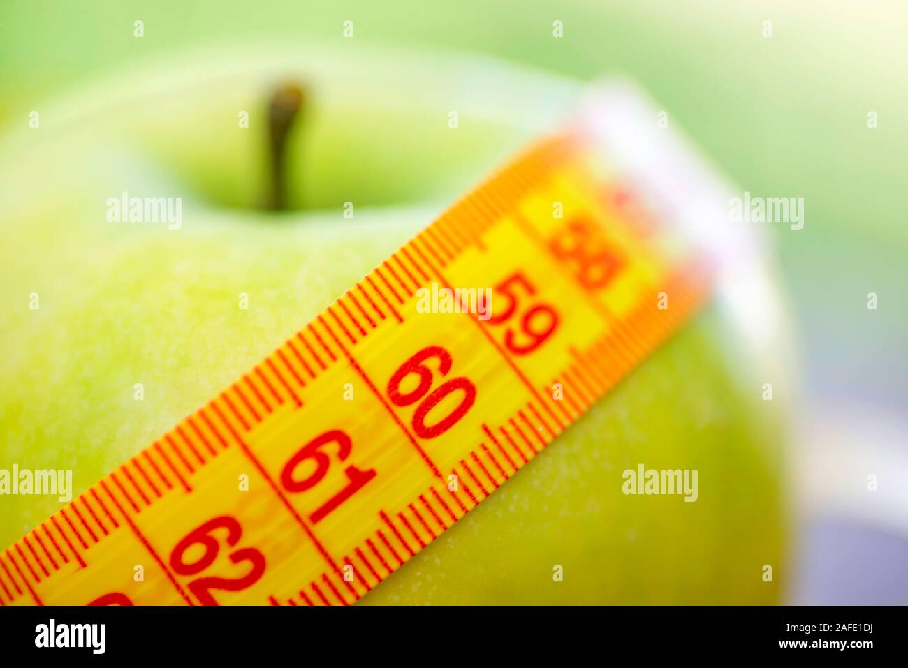 Concept de suivre un régime. Pomme verte avec ruban à mesurer. La perte de poids et de remise en forme gratuit. Banque D'Images