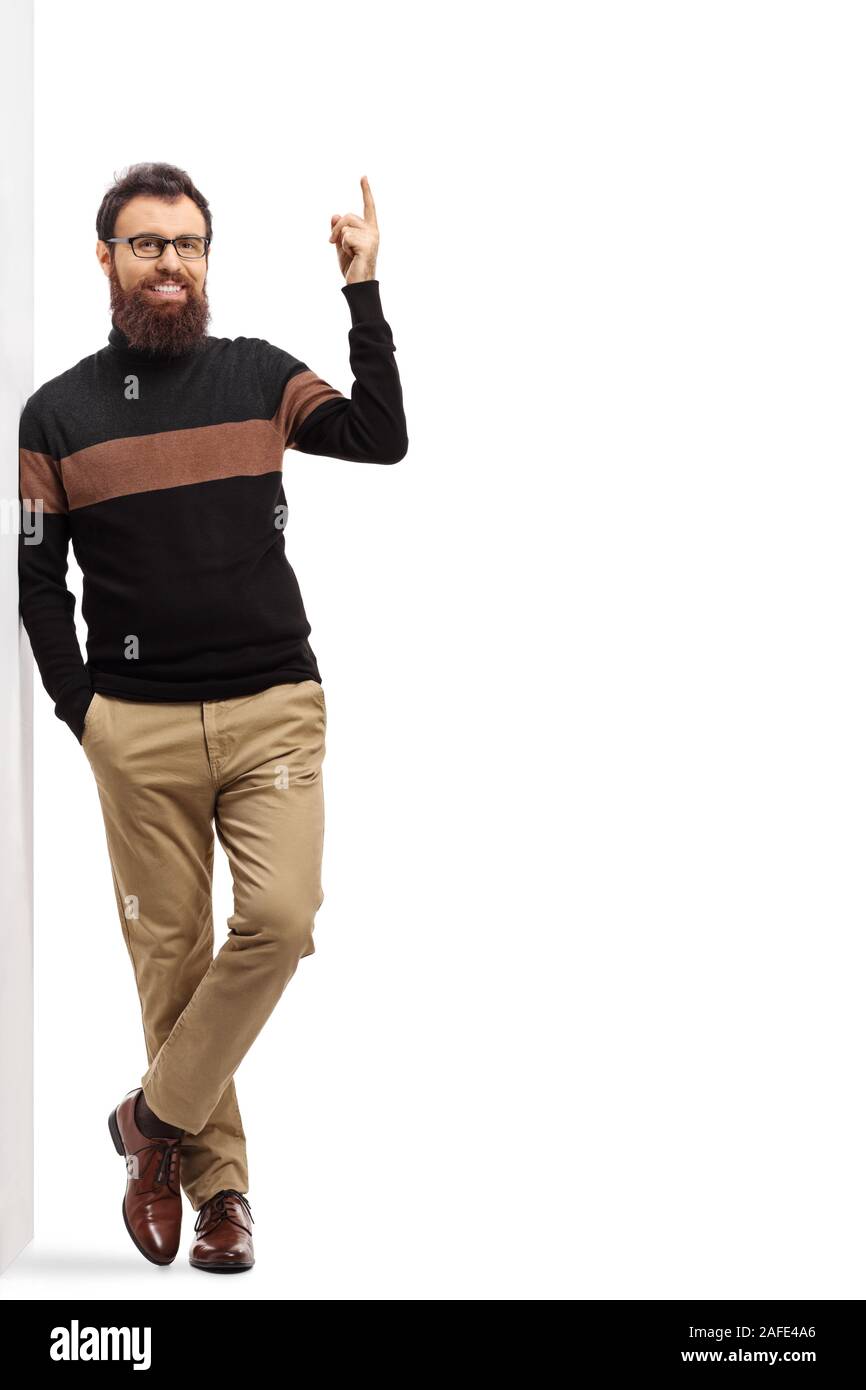 Portrait d'un homme barbu appuyée sur un mur et pointant au-dessus isolé sur fond blanc Banque D'Images