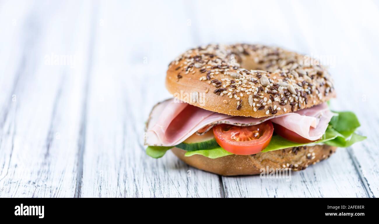 Ancienne table en bois avec Ham Bagel (selective focus ; close-up shot) Banque D'Images