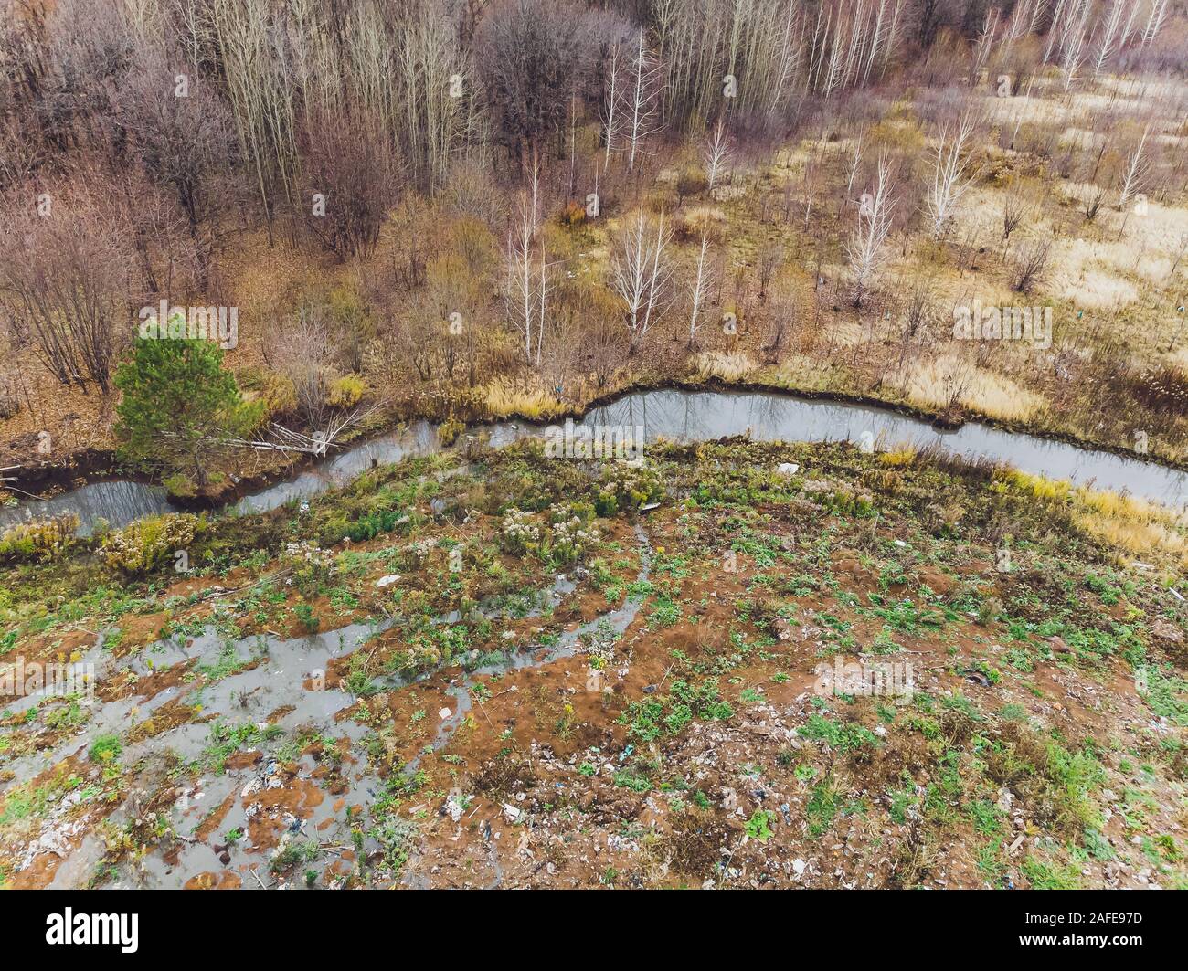 Le grand dépotoir de tas s'étend parallèlement à la Rivière, montagnes de déchets avec ciel nuageux retour la masse dans la lumière du jour,a des déchets de produits pétroliers sont Banque D'Images