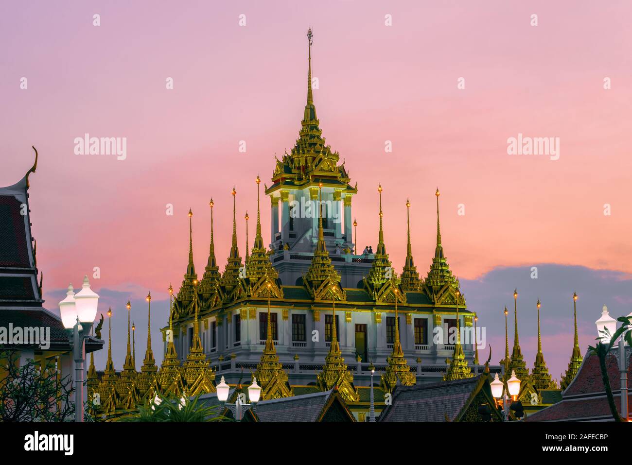 Haut de la Loha Prasat chedi du temple bouddhiste Wat Ratchanatdaram Voravihara contre le Ciel de coucher du soleil. Bangkok, Thaïlande Banque D'Images