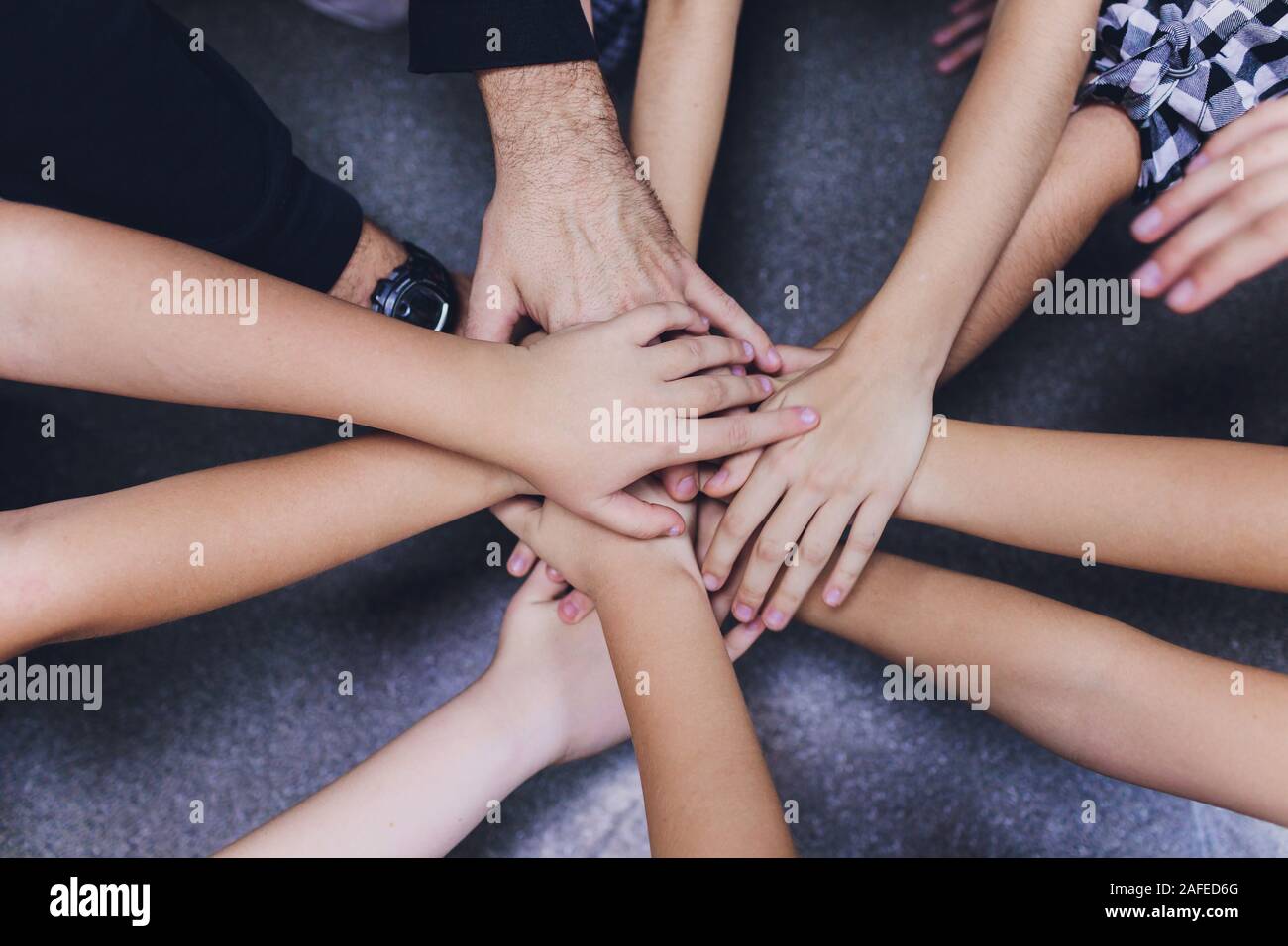 Les enfants de la diversité les mains ensemble sur l'équipe de globe Banque D'Images