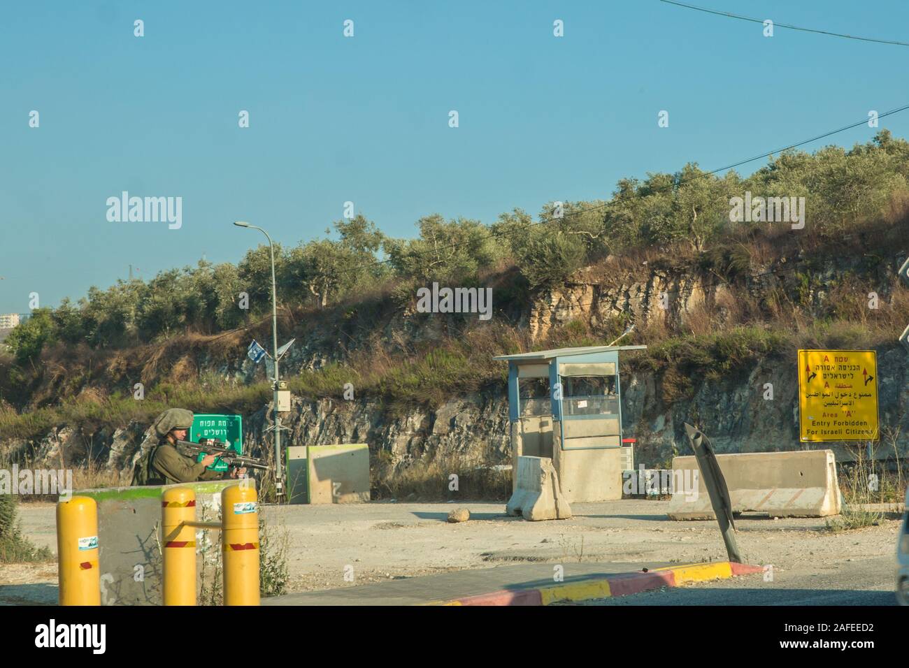Les soldats israéliens l'homme une barrière de la jonction de la route 55 en Cisjordanie Israël / Palestine Banque D'Images