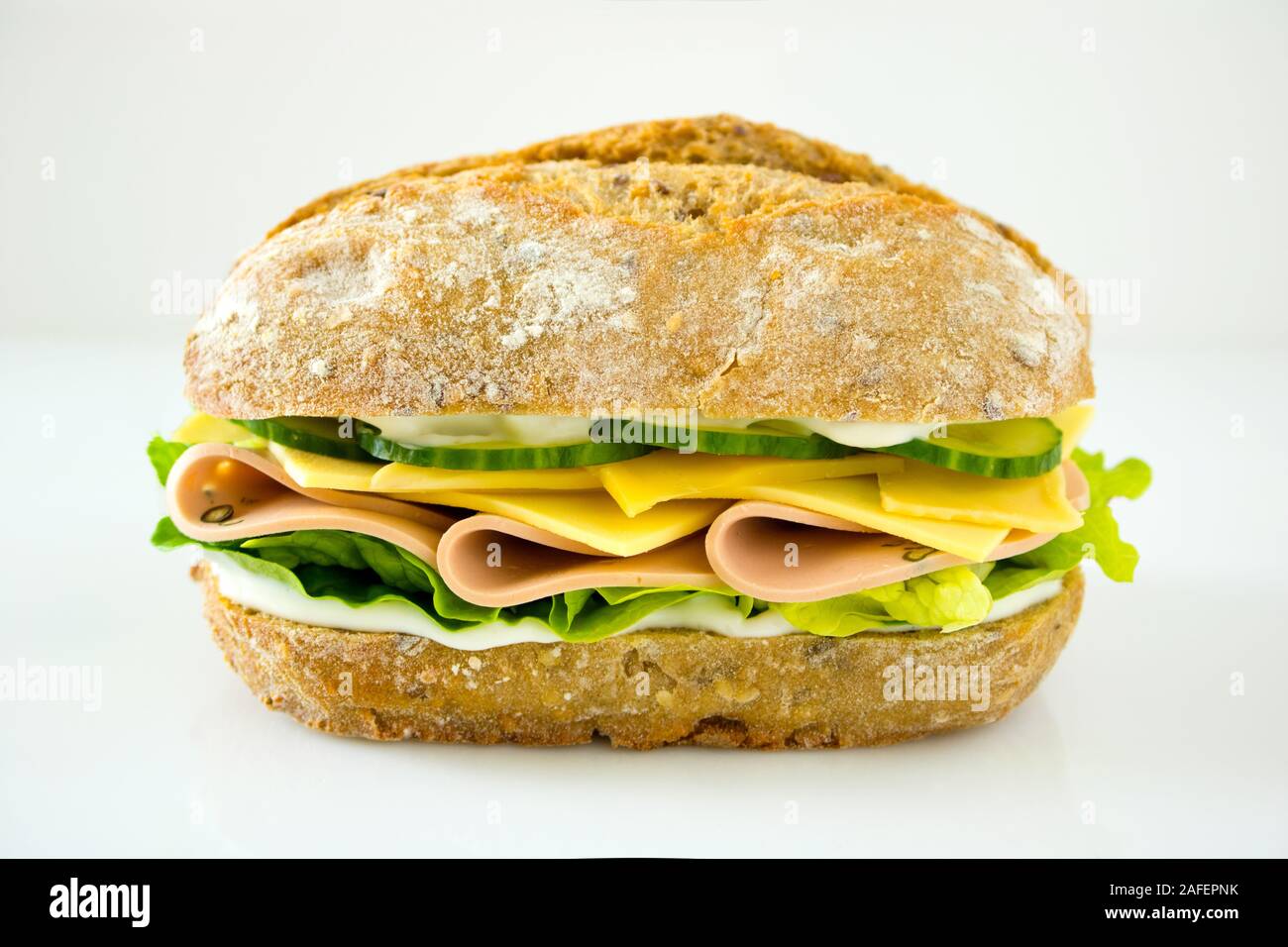 La photographie culinaire d'un sandwich au jambon et au fromage avec concombres sur un pain ciabatta de blé entier Banque D'Images