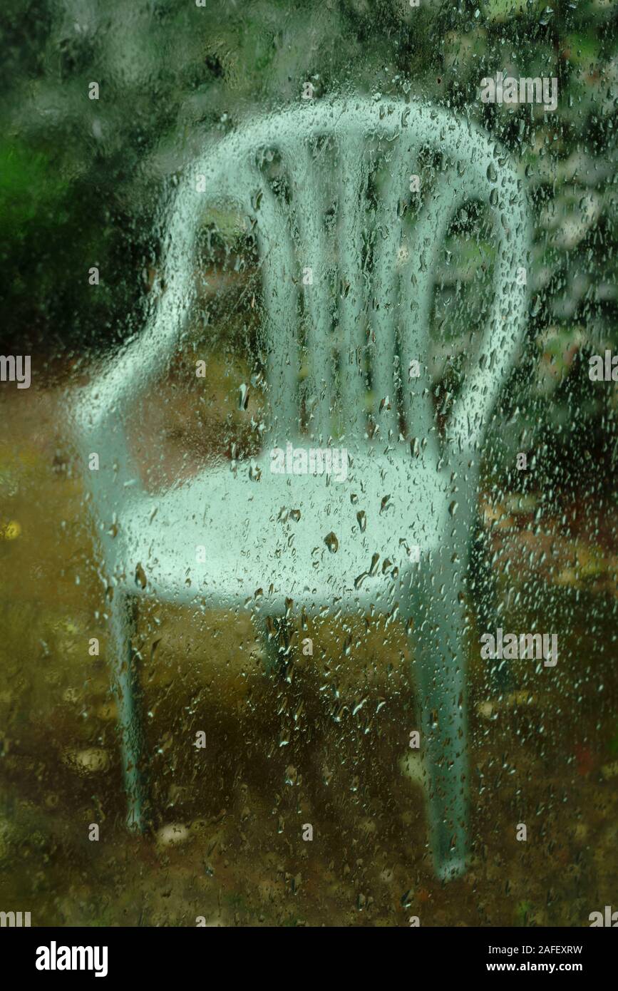 Une chaise de jardin un jour de pluie. Banque D'Images