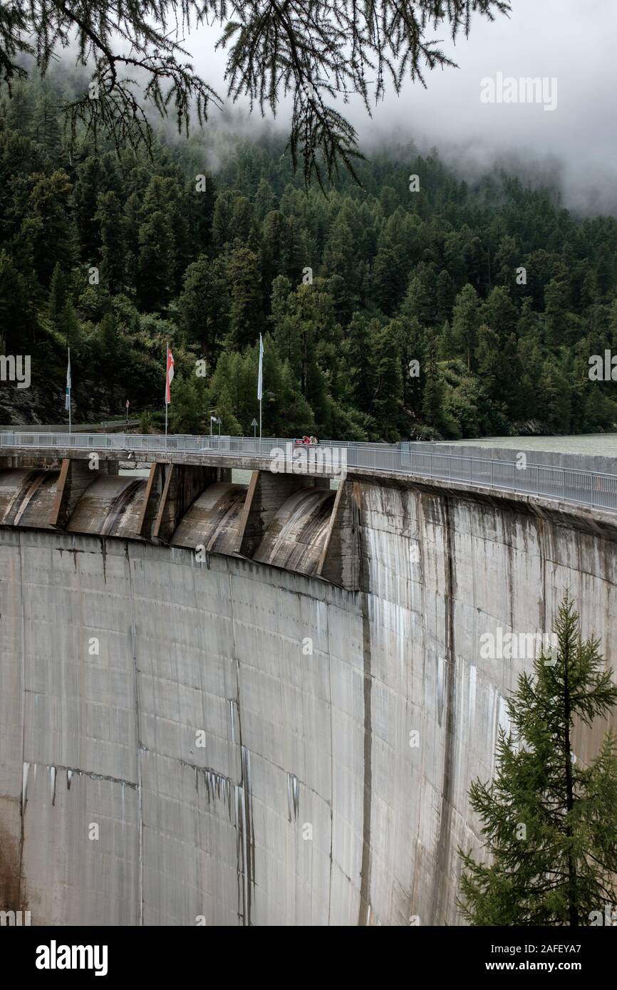 Les randonneurs dans la ligne de 74 mètres de haut barrage-voûte Zmuttbach là-haut, dans les Alpes Suisses près de Zermatt Banque D'Images