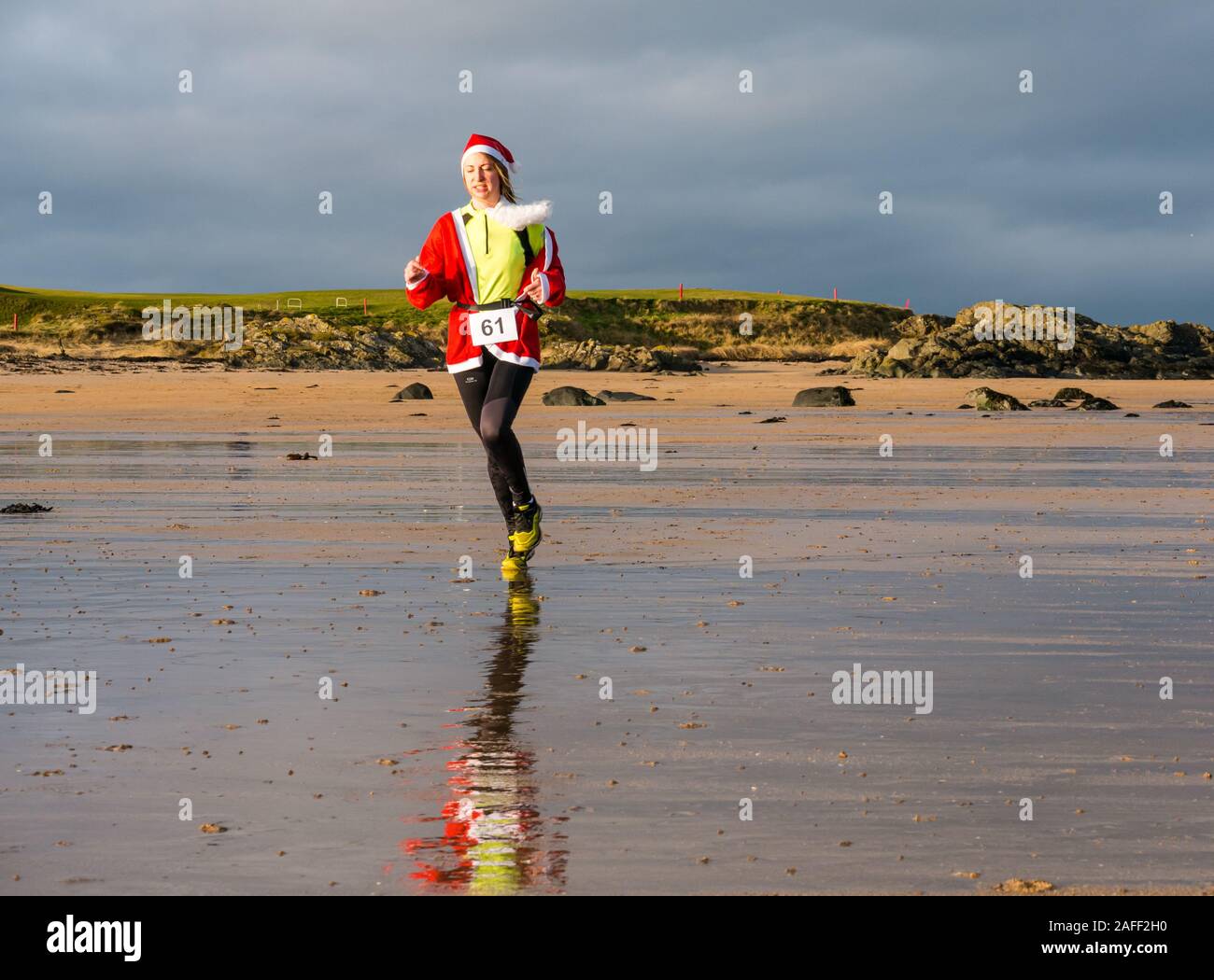 Woman in Santa run sur beach, North Berwick, East Lothian, Scotland, UK Banque D'Images