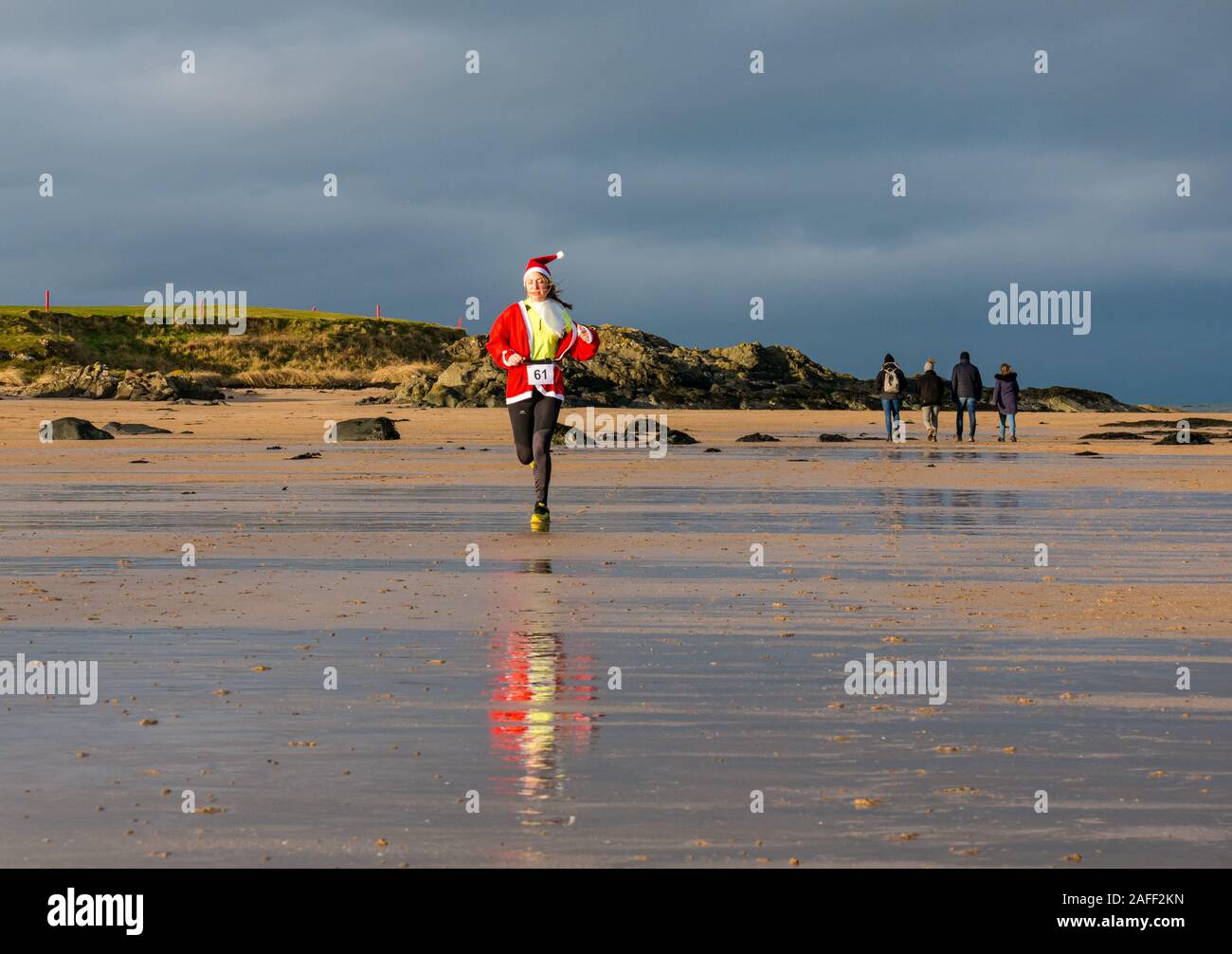 Woman in Santa run sur beach, North Berwick, East Lothian, Scotland, UK Banque D'Images