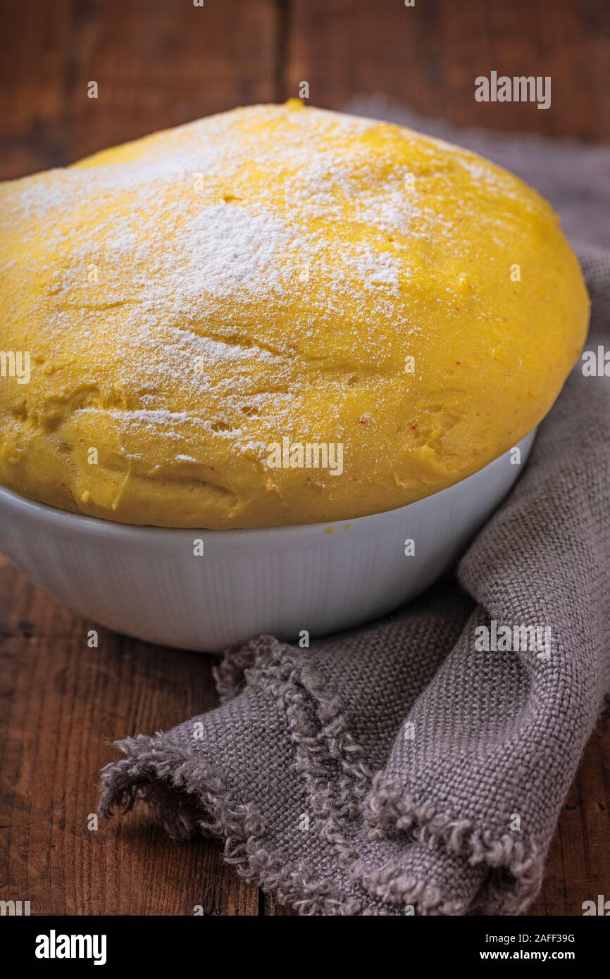 Bun safran pâte dans un bol close-up traditionnel suédois, lussebullar lussekatter ou pâte. Le bol est sur une table en bois rustique avec un tissu en lin sur Banque D'Images