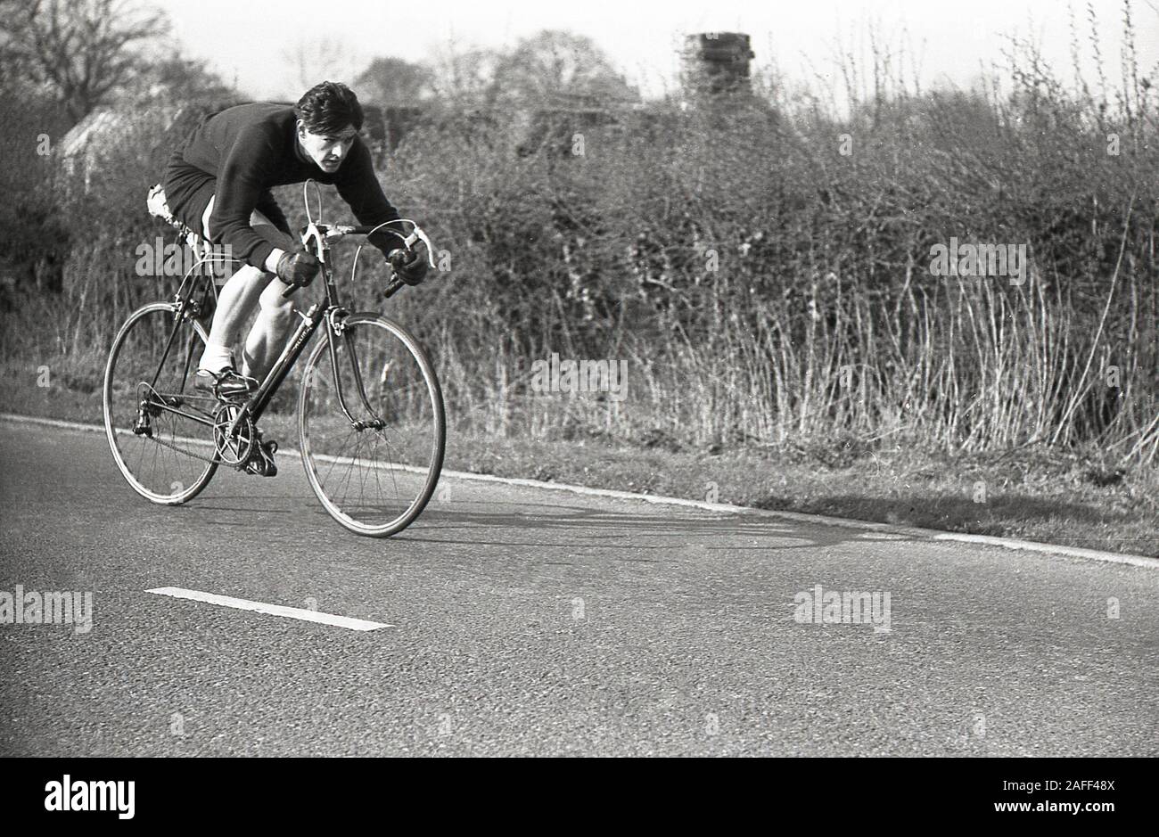 Années 1950, historique, un cycliste masculin sur une route de campagne prenant part à une course cycliste amateur, Angleterre, Royaume-Uni. Banque D'Images
